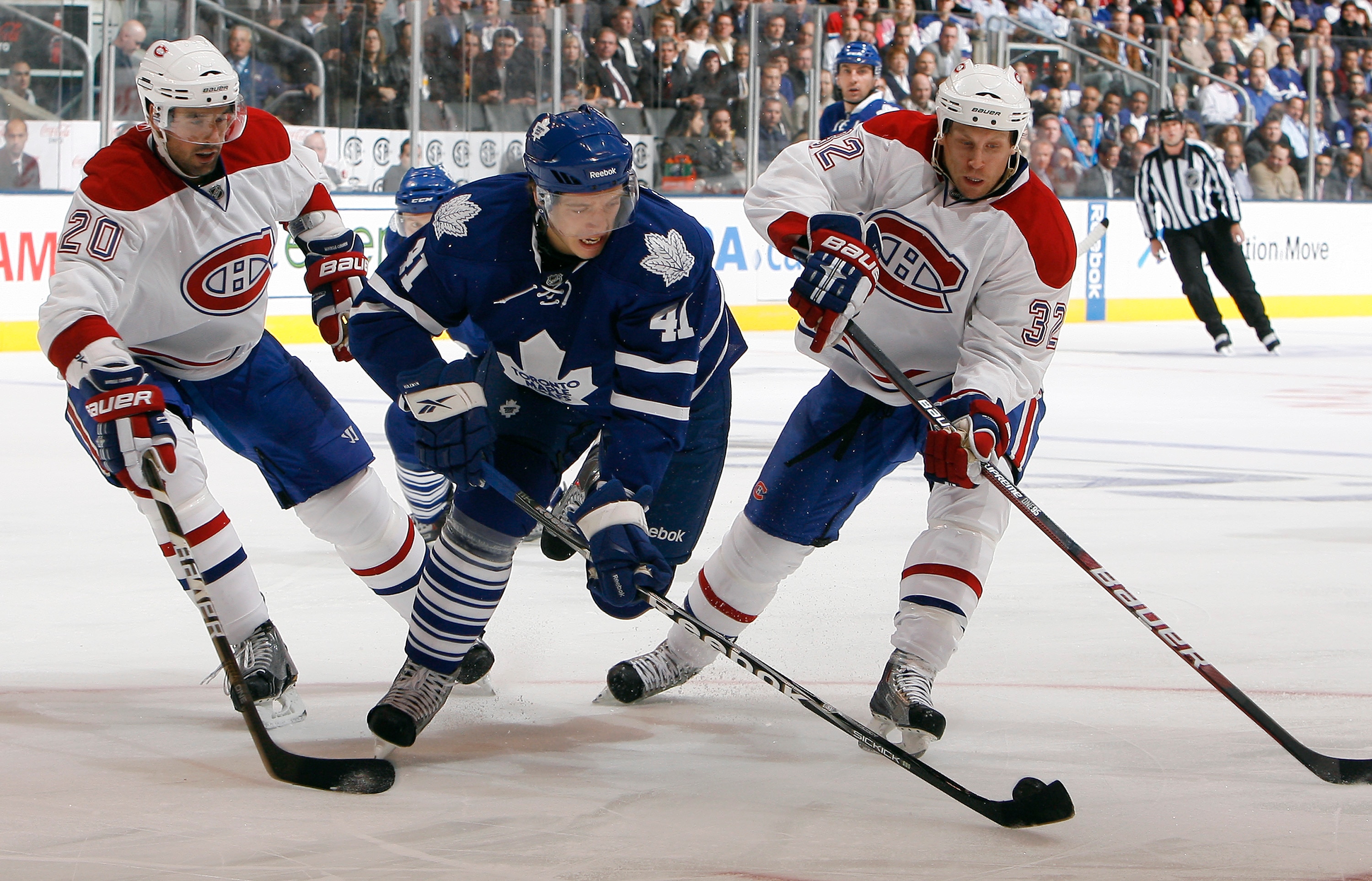 TORONTO - OCTOBER 7: Nikolai Kulemin #41 of the Toronto Maple Leafs charges past Ryan O'Byrne #20 and Travis Moen #32 of the Montreal Canadiens during a regular season NHL game against the Toronto Maple Leafs at the Air Canada Centre October 7, 2010 in To