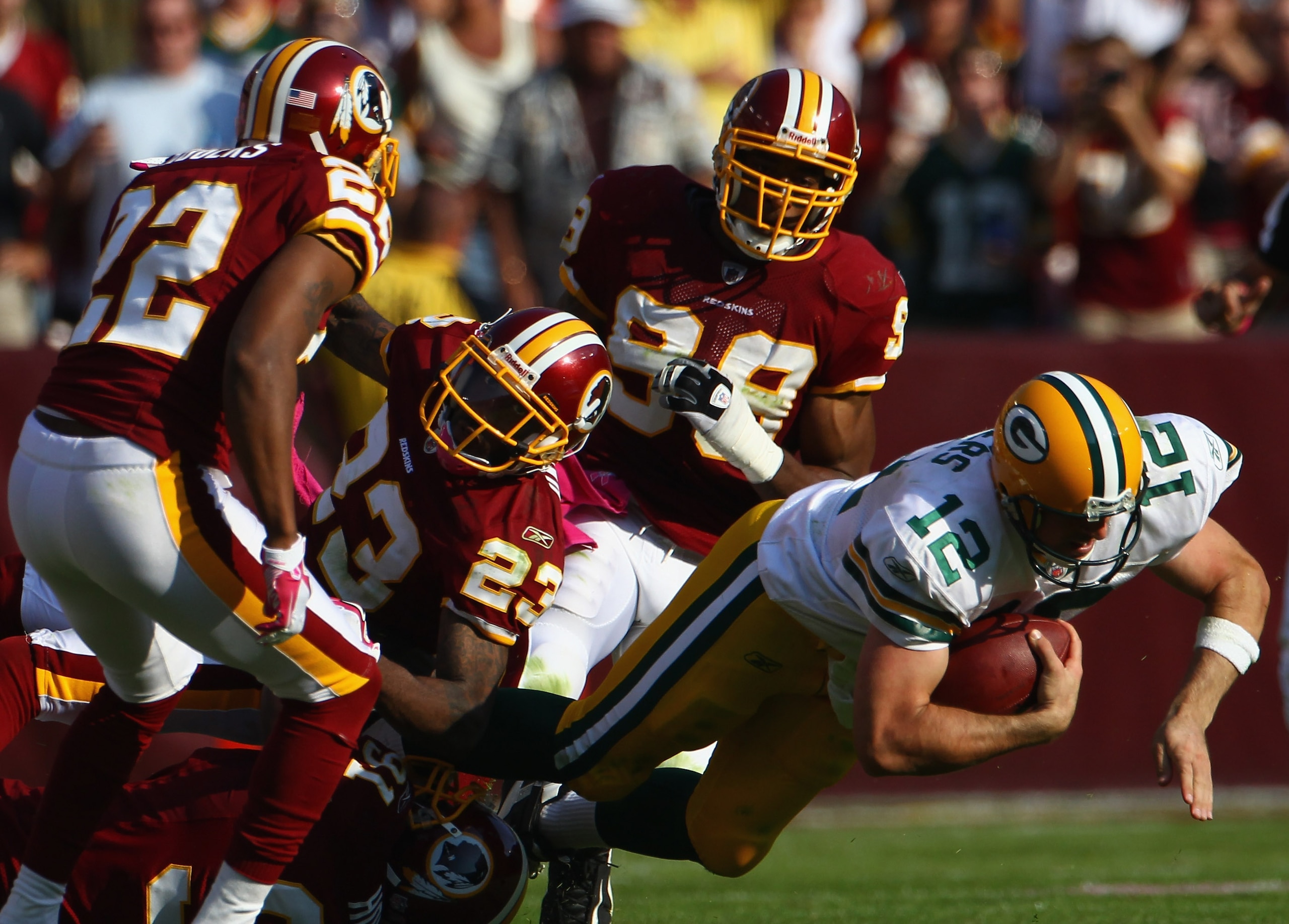 LANDOVER, MD - OCTOBER 10: Quarterback Aaron Rodgers #12 of the Green Bay Packers is brought down by DeAngelo Hall #23, Carlos Rogers #22, and Brian Orakpo #98 of the Washington Redskins in the fourth quarte at FedExField on October 10, 2010 in Landover,
