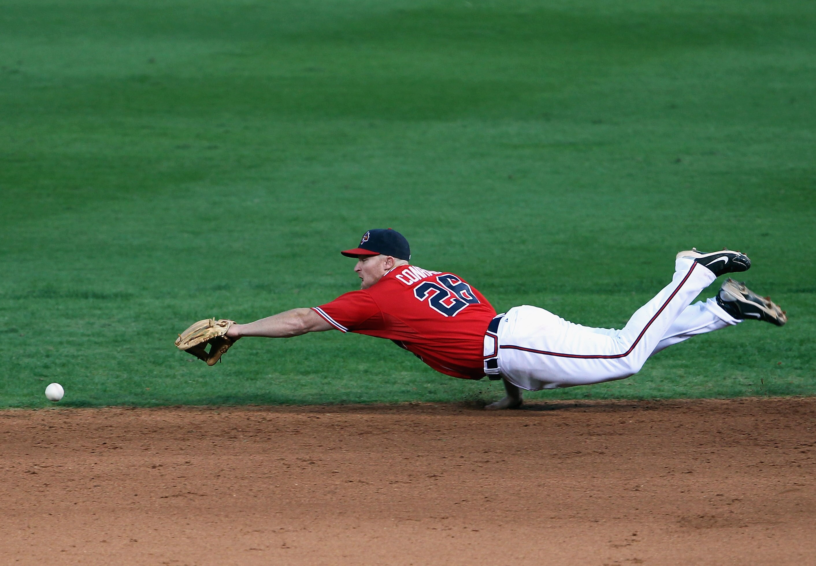 ATLANTA - OCTOBER 10:  Brooks Conrad #26 of the Atlanta Braves dives for a ball during Game Three of the NLDS of the 2010 MLB Playoffs against the San Francisco Giants on October 10, 2010 at Turner Field in Atlanta, Georgia.  (Photo by Jamie Squire/Getty