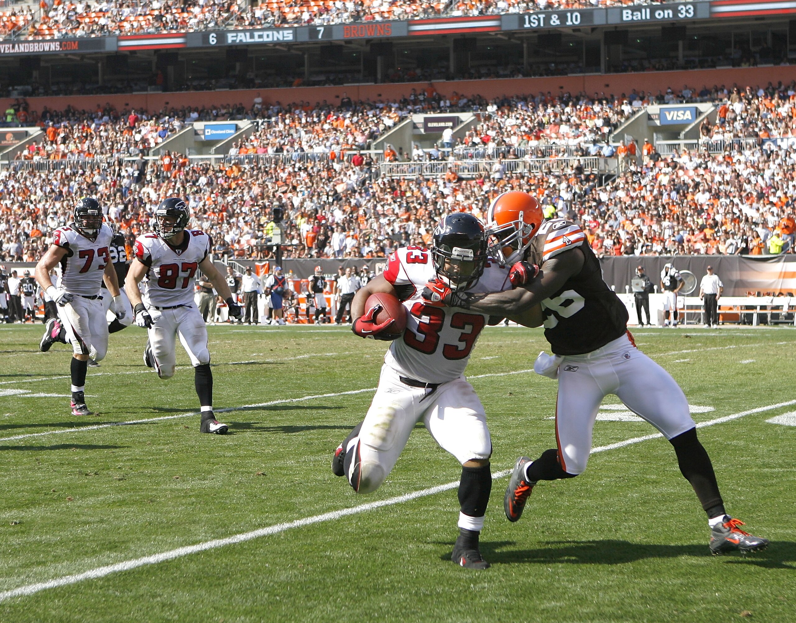 CLEVELAND - OCTOBER 10:  Running back Michael Turner #33 of the Atlanta Falcons runs the ball as he is hit by defensive back Abram Elam #26 of the Cleveland Browns at Cleveland Browns Stadium on October 10, 2010 in Cleveland, Ohio.  (Photo by Matt Sulliva