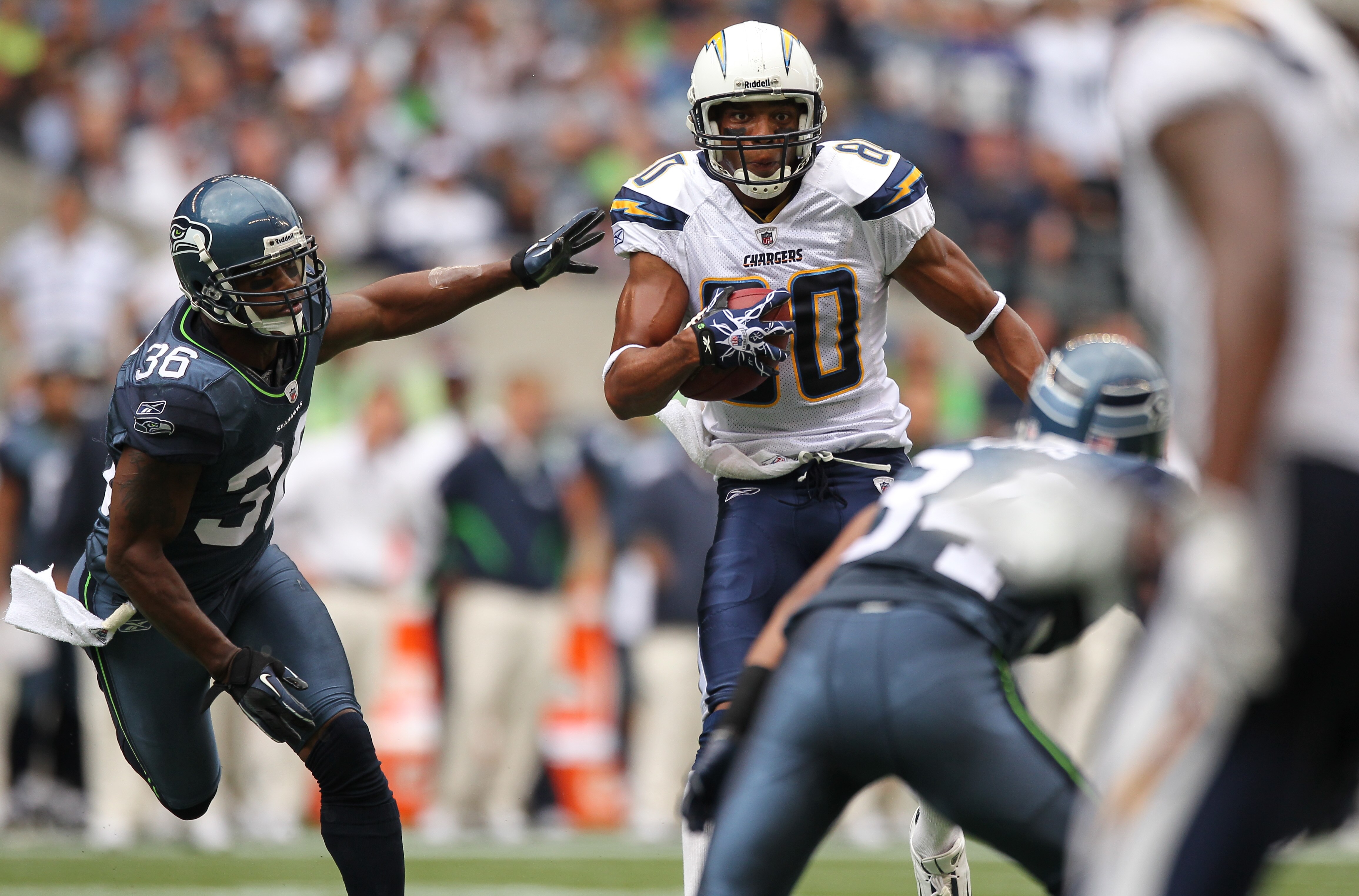 SEATTLE - SEPTEMBER 26:  Wide receiver Malcom Floyd #80 of the San Diego Chargers rushes against Roy Lewis #34 and Lawyer Milloy #36 of the Seattle Seahawks at Qwest Field on September 26, 2010 in Seattle, Washington. (Photo by Otto Greule Jr/Getty Images