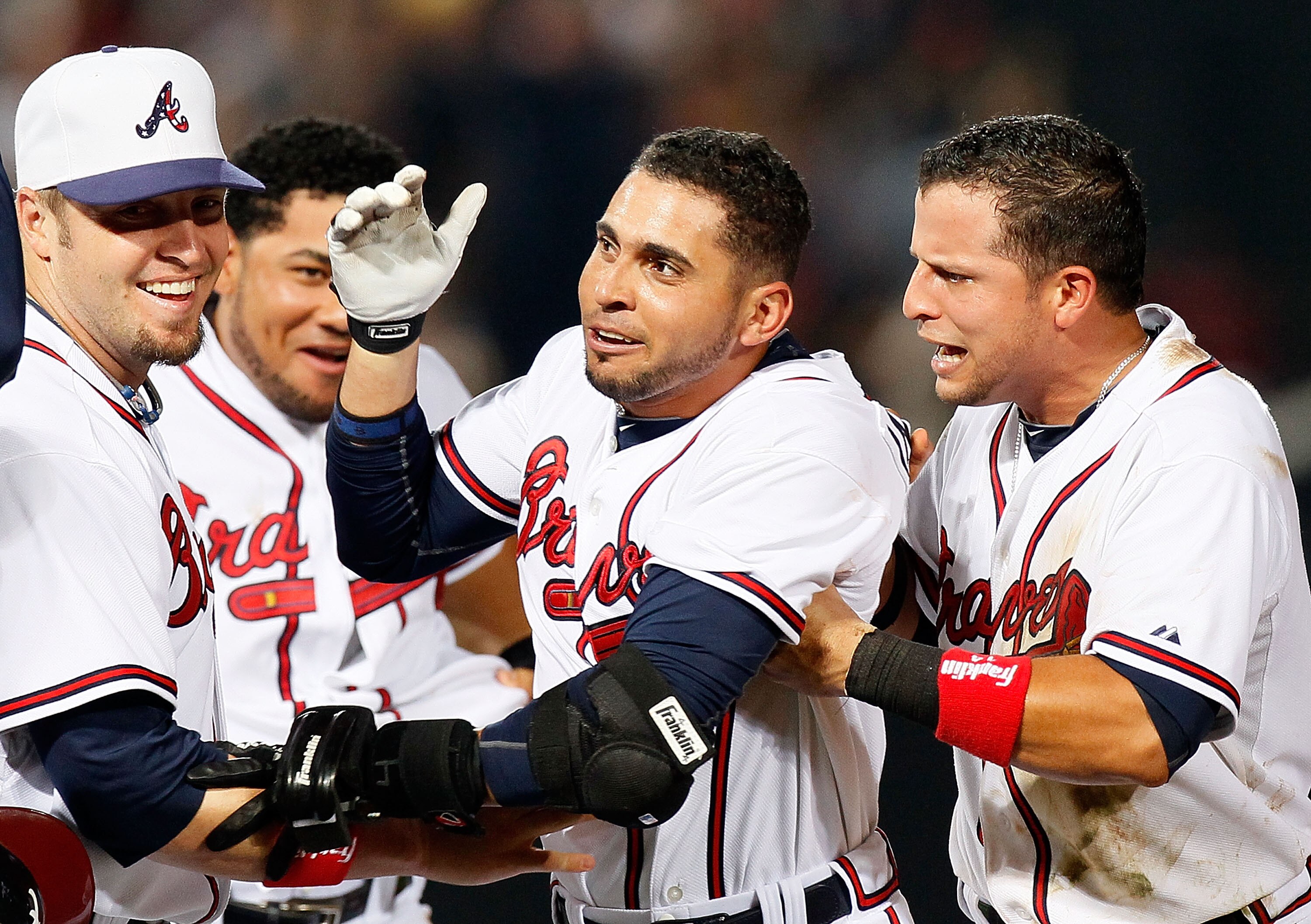 ATLANTA - JULY 02:  Eric Hinske #20 and Martin Prado #14 of the Atlanta Braves celebrate with Omar Infante #4 after Infante's two-run single in the 11th inning to give the Braves a 4-3 win over the Florida Marlins at Turner Field on July 2, 2010 in Atlant