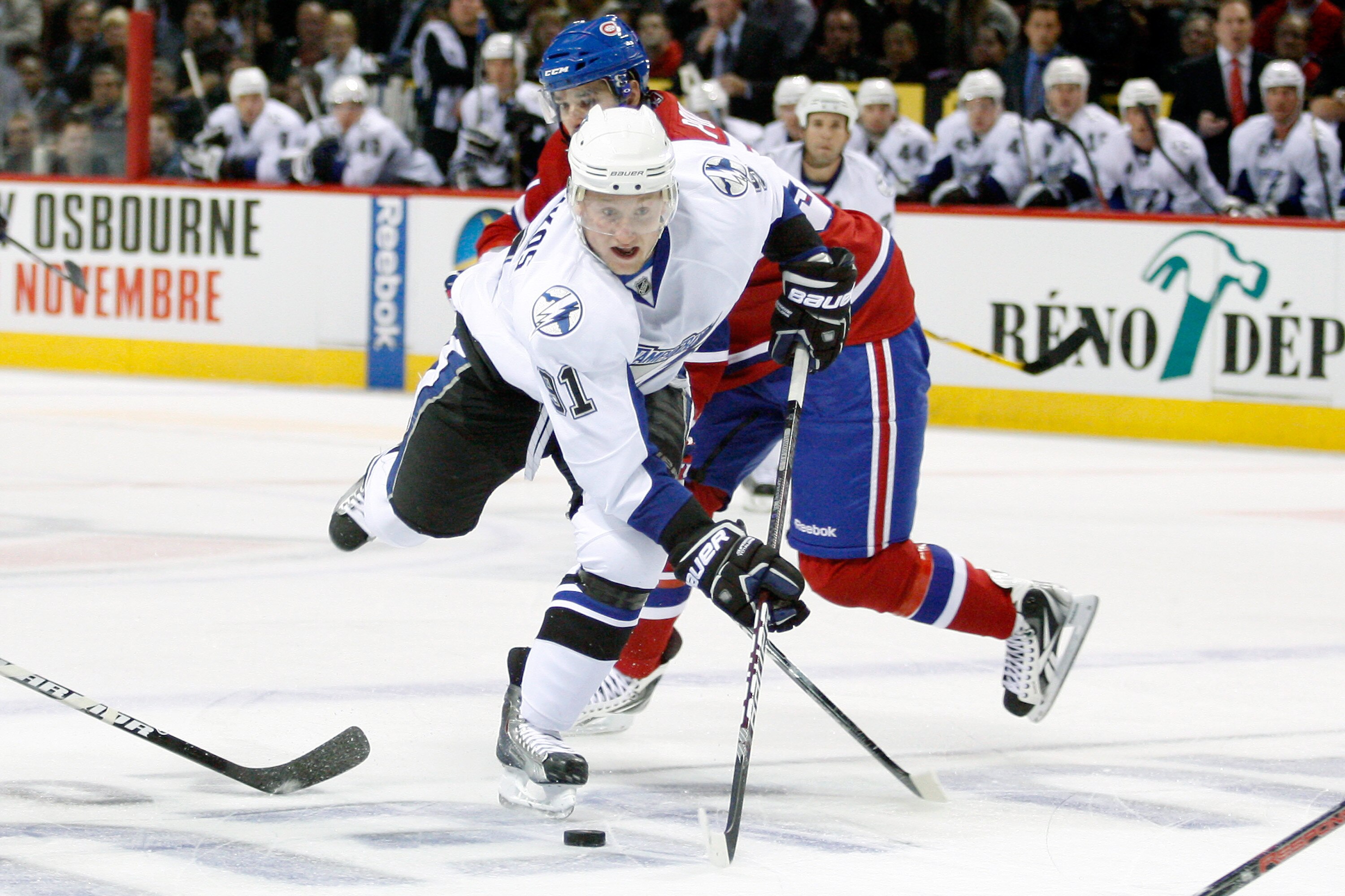 MONTREAL, CANADA - OCTOBER 13:  Steven Stamkos #91 of the Tampa Bay Lightning stick handles the puck past Benoit Pouliot #57 of the Montreal Canadiens during the NHL game at the Bell Centre on October 13, 2010 in Montreal, Quebec, Canada.   The Lightning 