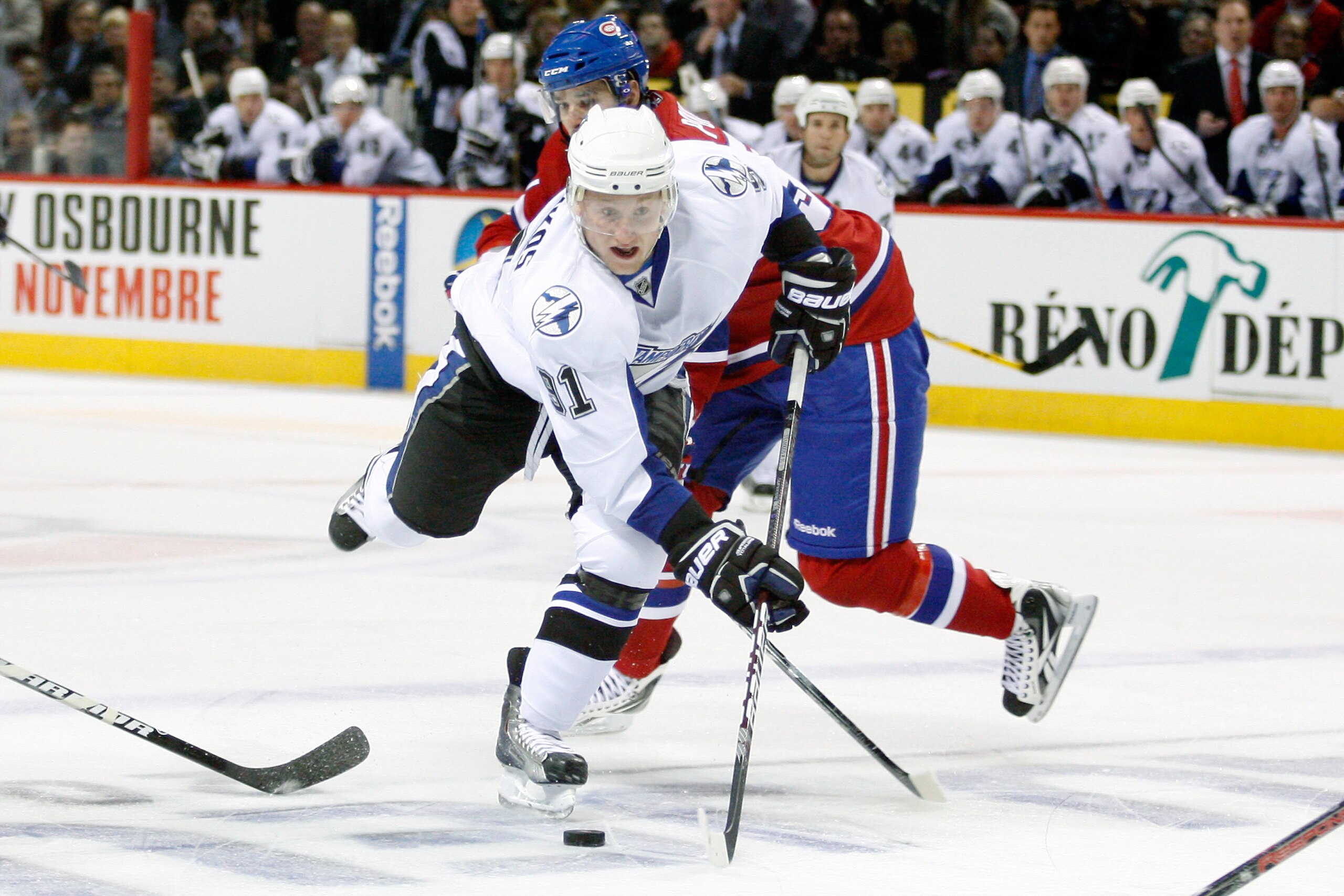 MONTREAL, CANADA - OCTOBER 13:  Steven Stamkos #91 of the Tampa Bay Lightning stick handles the puck past Benoit Pouliot #57 of the Montreal Canadiens during the NHL game at the Bell Centre on October 13, 2010 in Montreal, Quebec, Canada.   The Lightning 