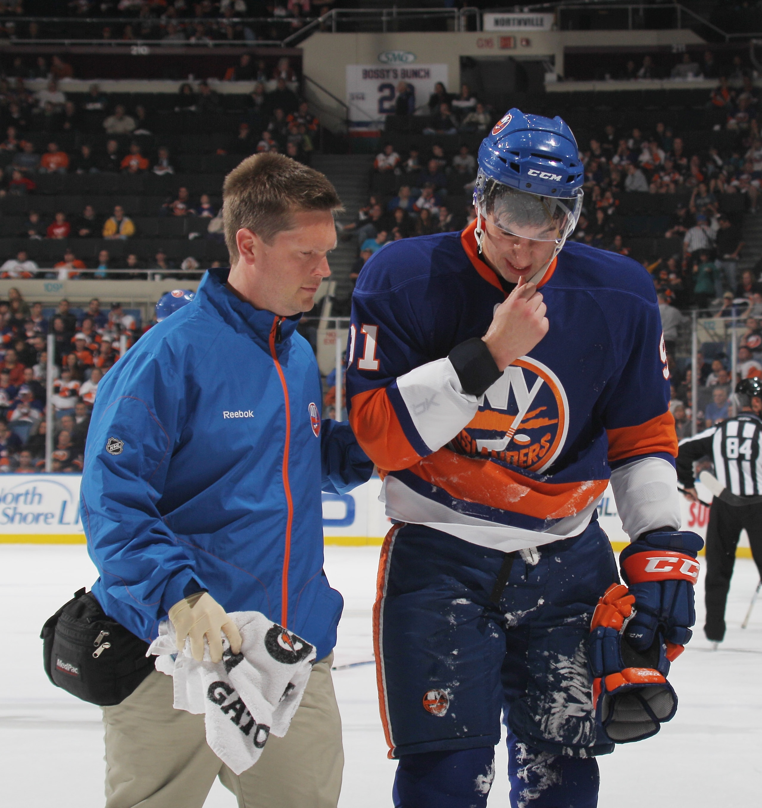 UNIONDALE, NY - OCTOBER 09: Trainer Garrett Timms walks John Tavares #91 of the New York Islanders off the ice after his injury in the game against the Dallas Stars at the Nassau Coliseum on October 9, 2010 in Uniondale, New York. The Stars defeated the I