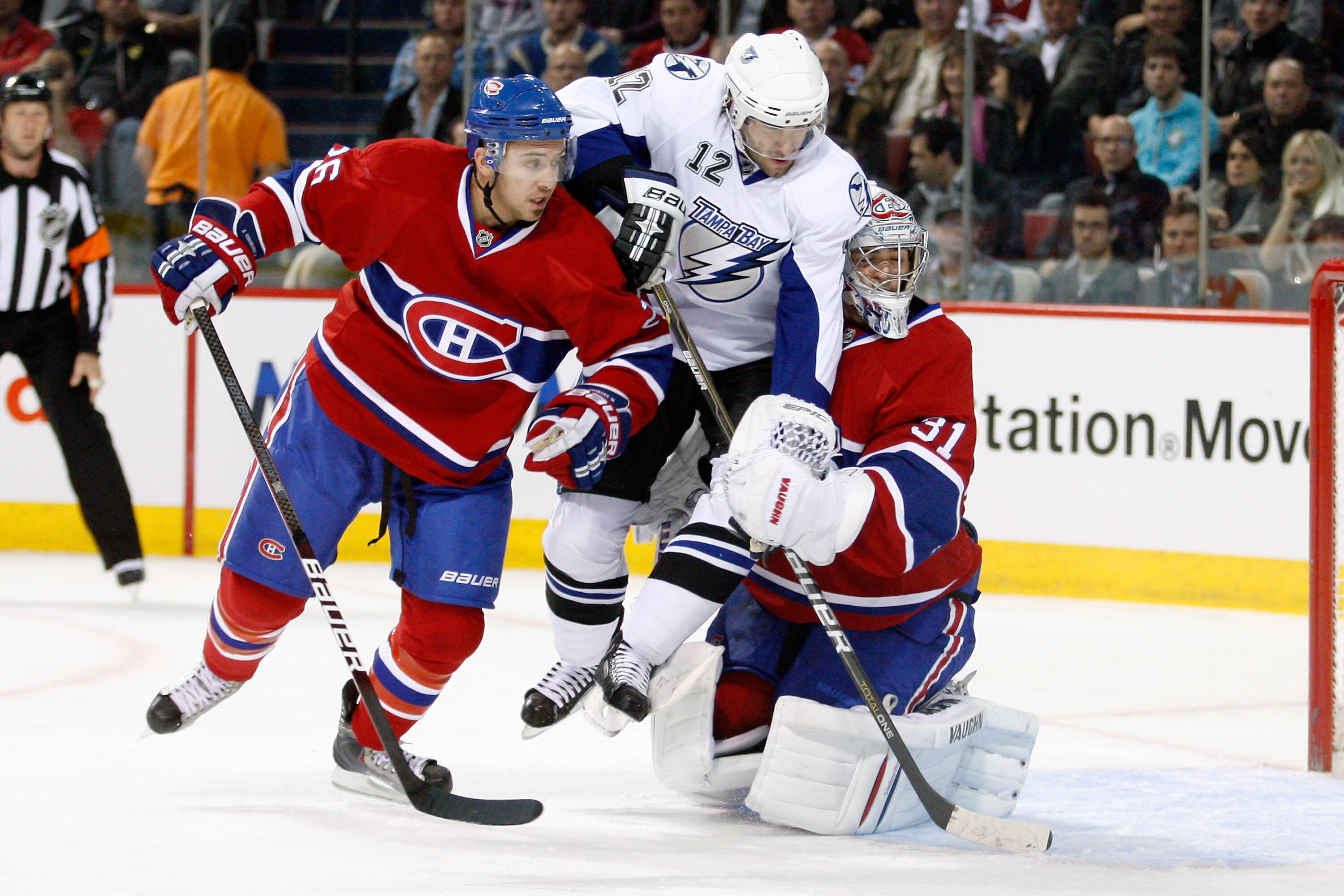 MONTREAL, CANADA - OCTOBER 13:  Josh Gorges #26 of the Montreal Canadiens body checks Simon Gagne #12 of the Tampa Bay Lightning into team mate Carey Price #31 during the NHL game at the Bell Centre on October 13, 2010 in Montreal, Quebec, Canada.   The L