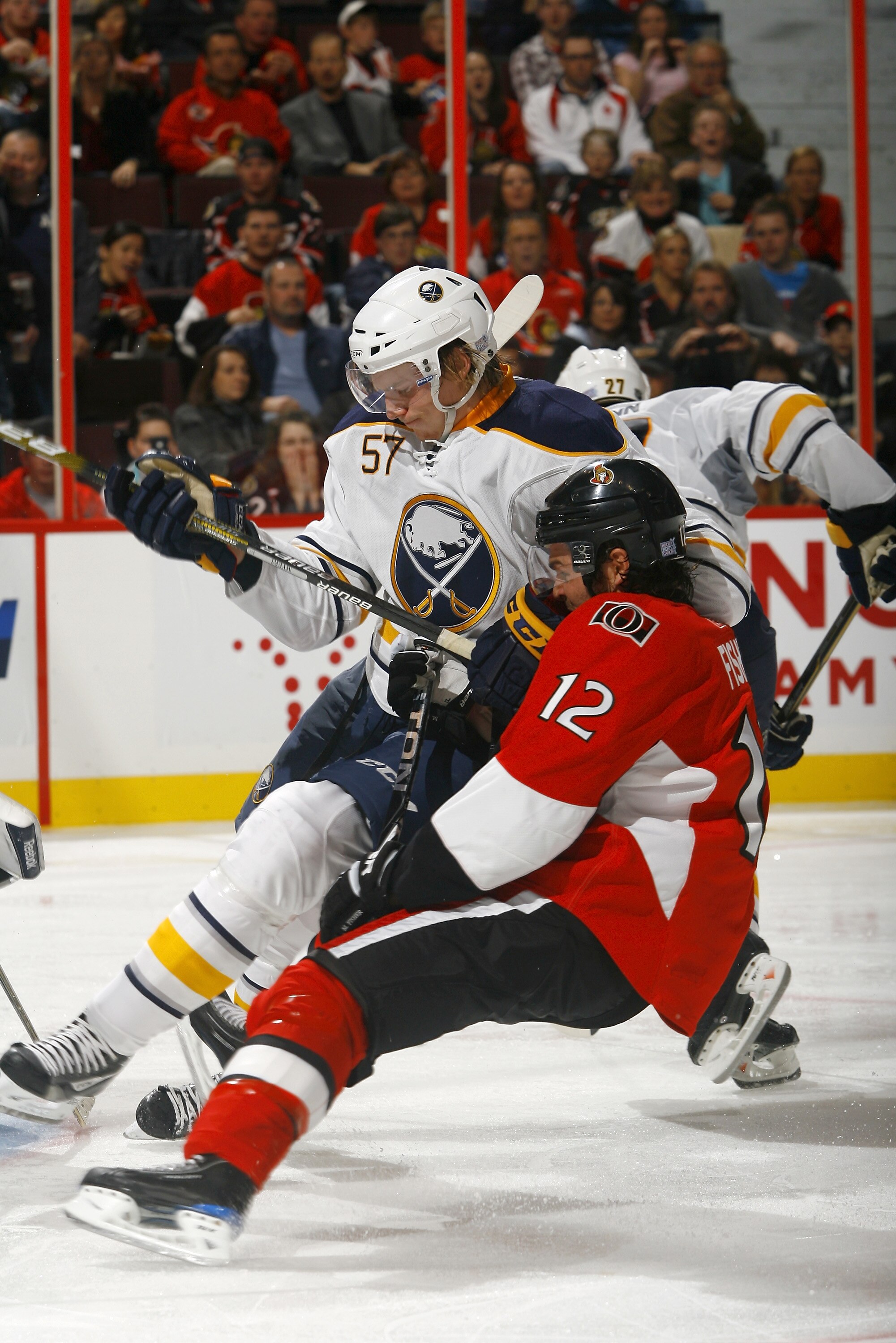 OTTAWA, CANADA - OCTOBER 08:  Tyler Myers #57 of the Buffalo Sabres knocks Mike Fisher #12 of the Ottawa Senators to the ice during a game at Scotiabank Place on October 8, 2010 in Ottawa, Ontario, Canada.  (Photo by Phillip MacCallum/Getty Images)