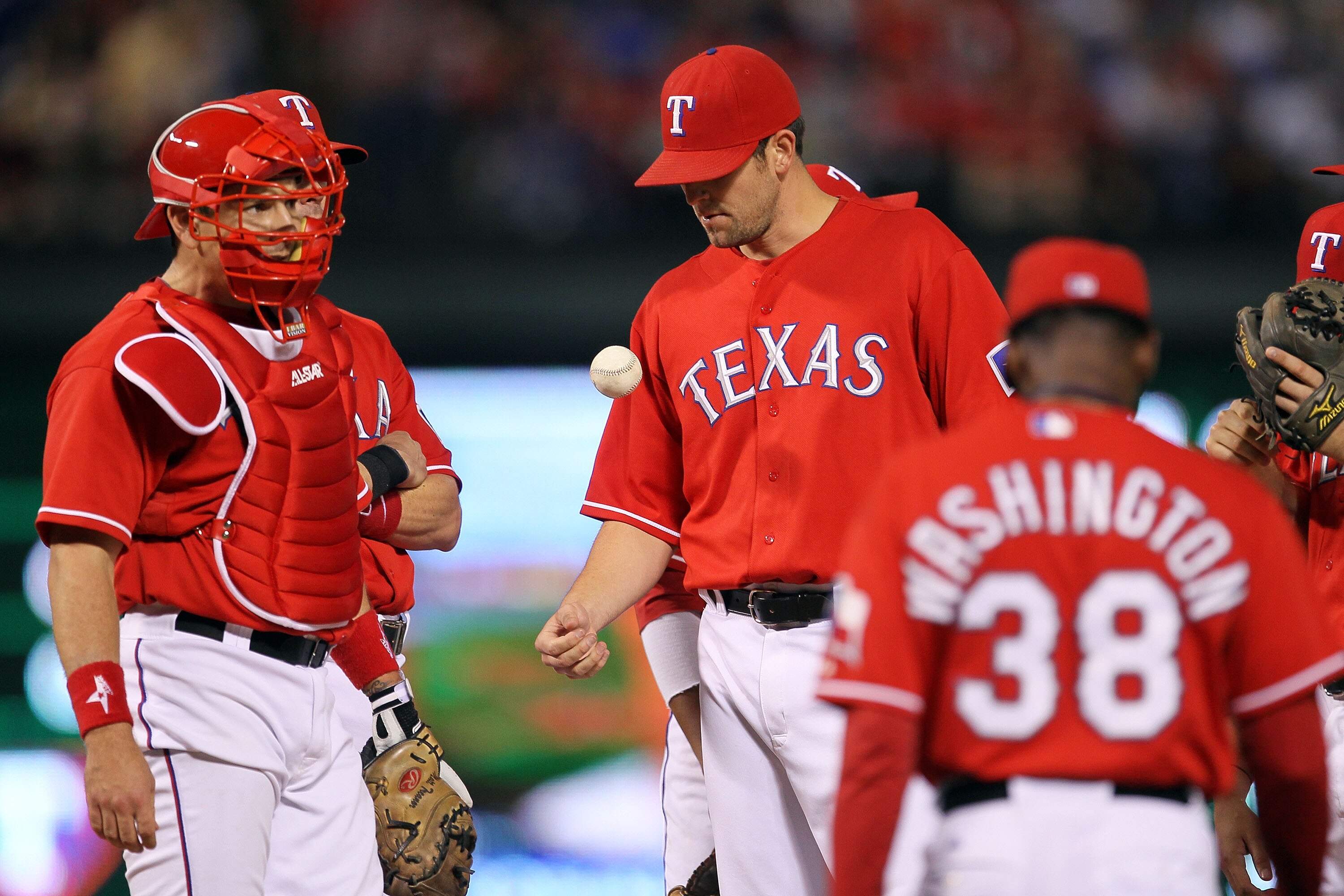ARLINGTON, TX - OCTOBER 15:  Darren O'Day #56 of the Texas Rangers tosses the ball in the air as Manager Ron Washington #38 walks out to take O'Day out of the game in the top of the eighth inning against the New York Yankees in Game One of the ALCS during