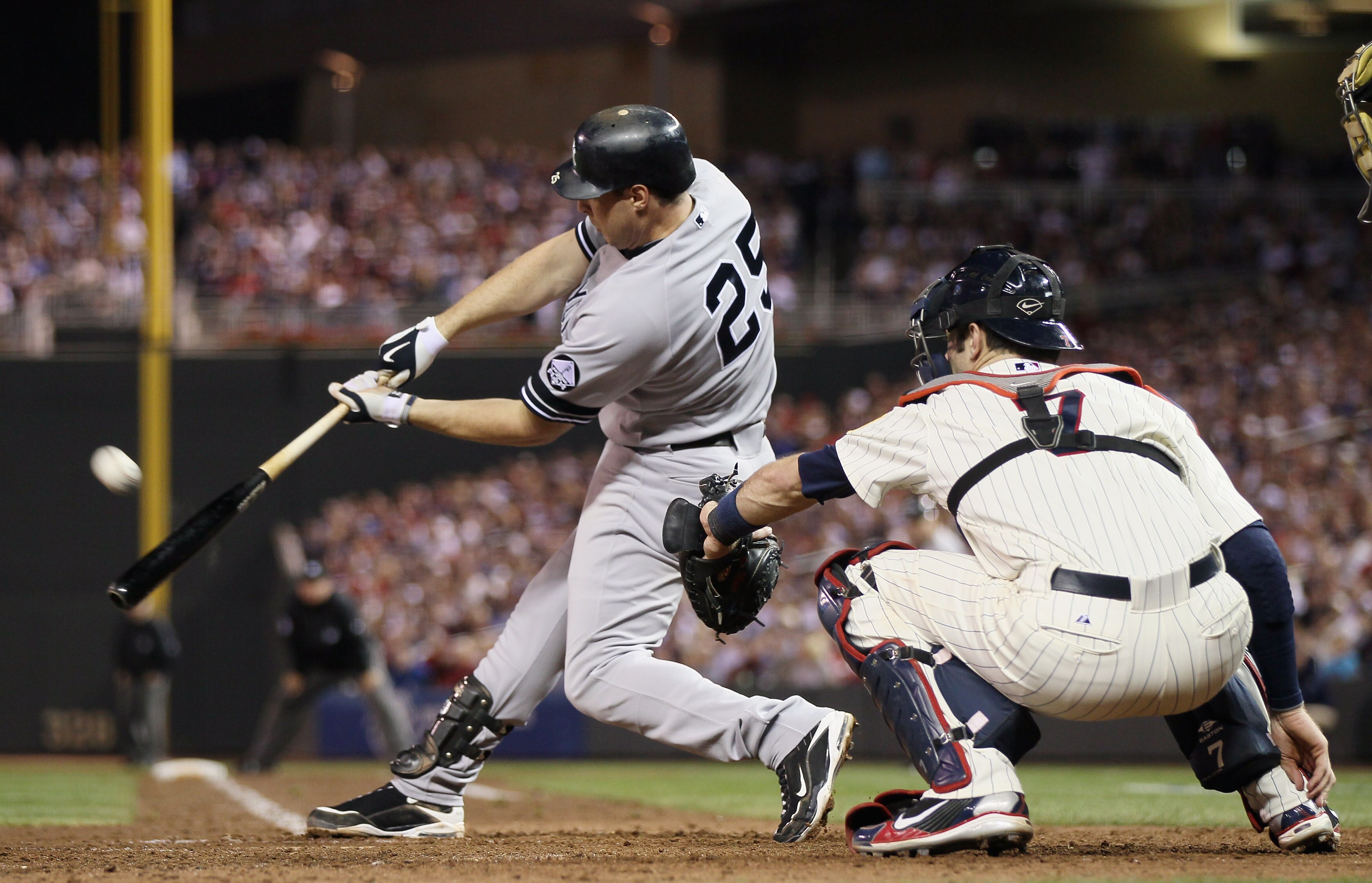 MINNEAPOLIS - OCTOBER 07:  Mark Teixeira #25 of the New York Yankees gets a hit as Joe Mauer #7 of the Minnesota Twins catches during game two of the ALDS on October 7, 2010 at Target Field in Minneapolis, Minnesota.  (Photo by Elsa/Getty Images)