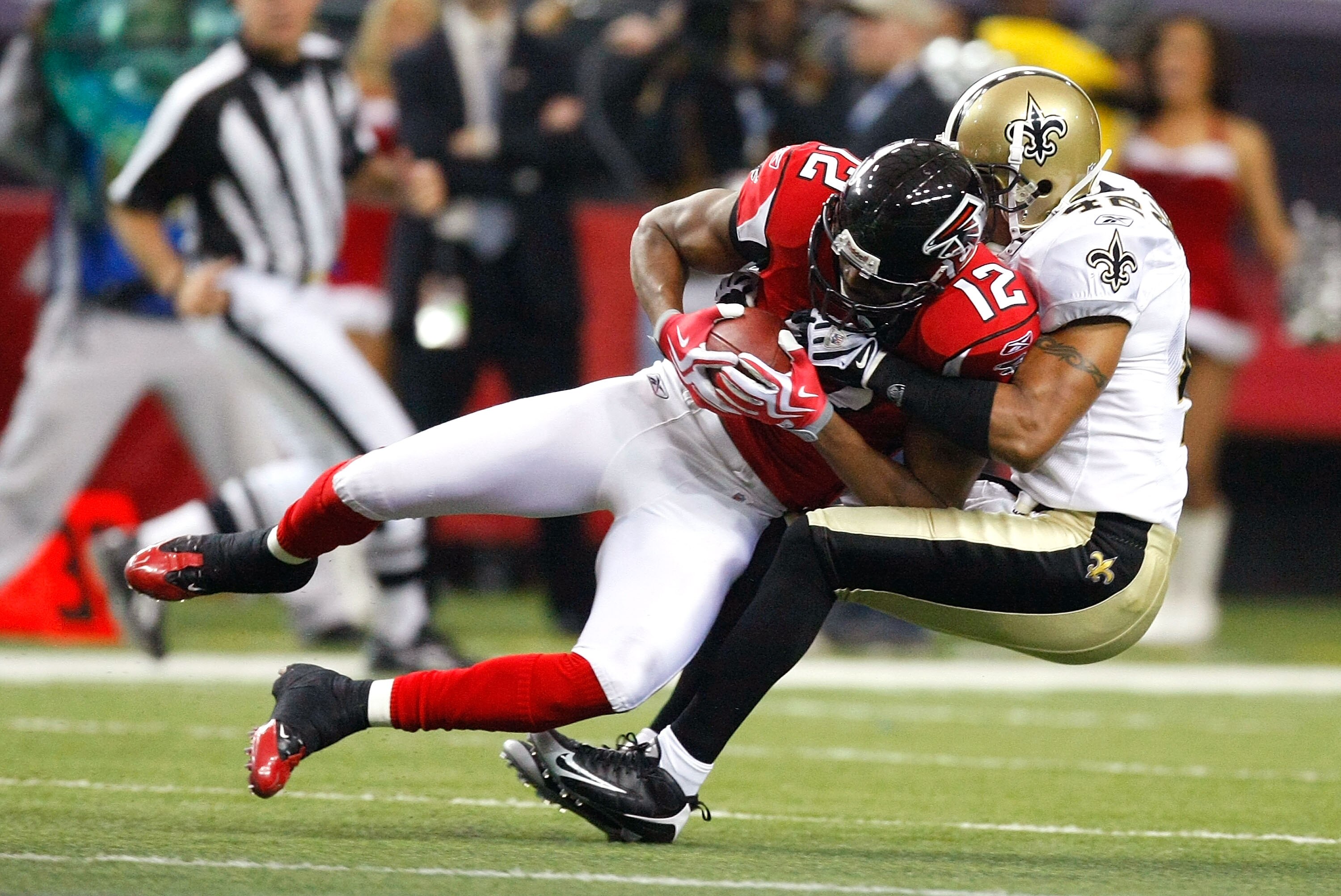 ATLANTA - DECEMBER 13:  Darren Sharper #42 of the New Orleans Saints tackles Michael Jenkins #12 of the Atlanta Falcons at Georgia Dome on December 13, 2009 in Atlanta, Georgia. The Saints won 26-23.  (Photo by Kevin C. Cox/Getty Images)