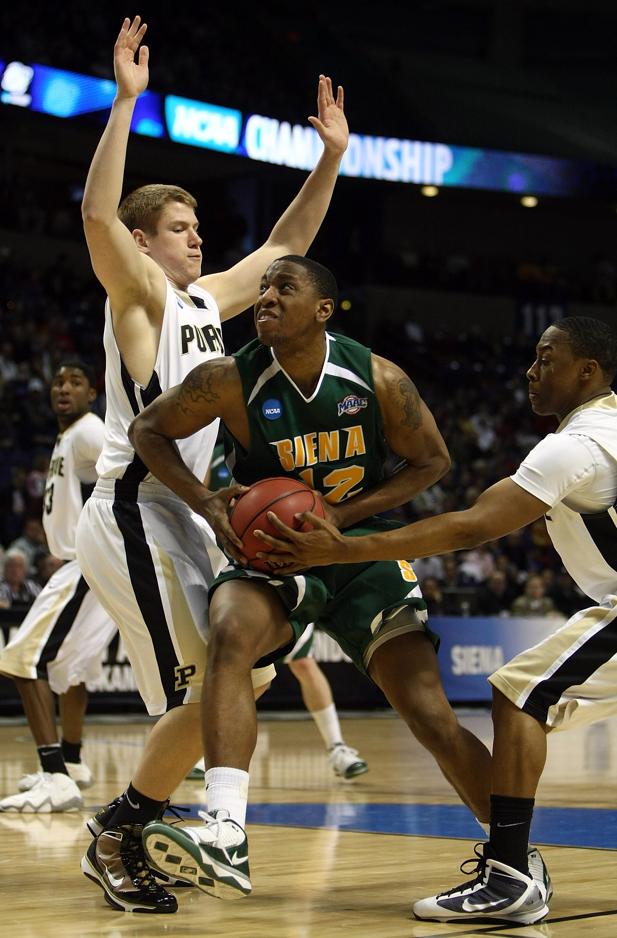 SPOKANE, WA - MARCH 19:  Alex Franklin #42 of the Siena Saints drives against Patrick Bade #41 of the Purdue Boilermakers during the first round of the 2010 NCAA men's basketball tournament at Spokane Arena on March 19, 2010 in Spokane, Washington.  (Phot