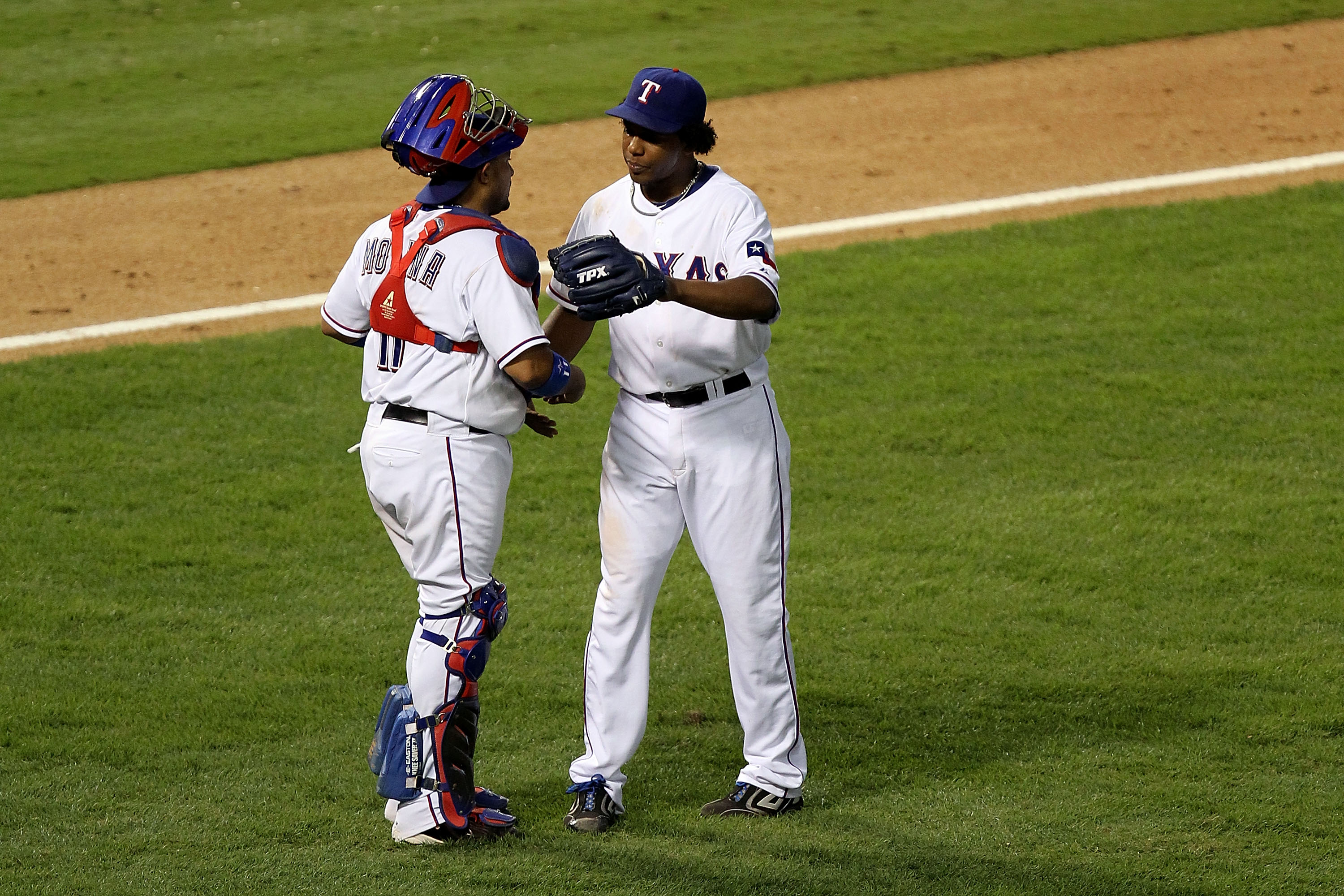 ARLINGTON, TX - OCTOBER 16: (L-R) Bengie Molina #11 and Neftali Feliz #30 of the Texas Rangers celebrate after they won 7-2 against the New York Yankees in Game Two of the ALCS during the 2010 MLB Playoffs at Rangers Ballpark in Arlington on October 16, 2