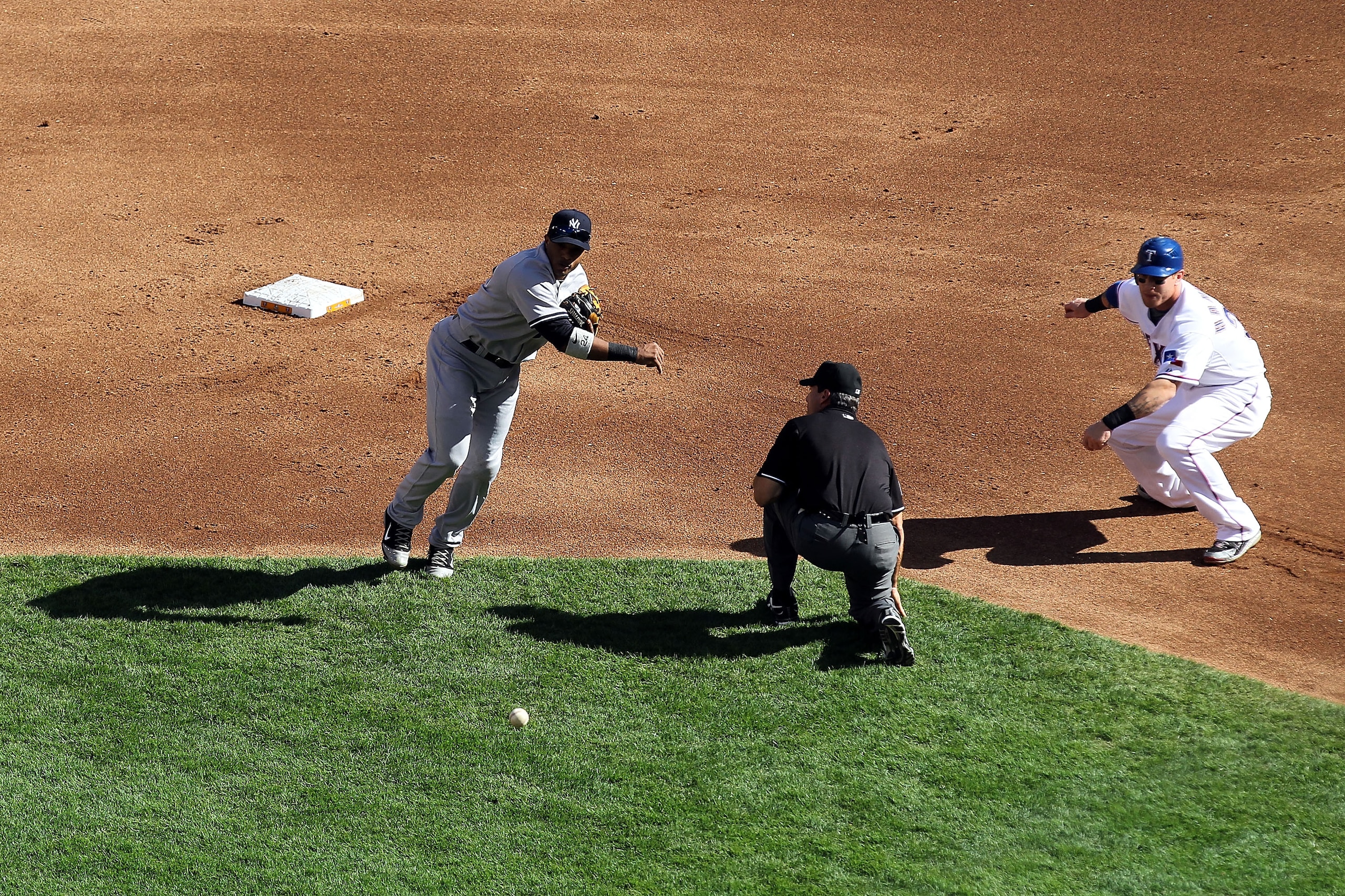 ARLINGTON, TX - OCTOBER 16:  Robinson Cano #24 of the New York Yankees throws the ball to home plate in a failed attempt to throw out Elvis Andrus #1 (not pictured) of he Texas Rangers on a double steal attempt by Andrus and Josh Hamilton #32 (R) in Game