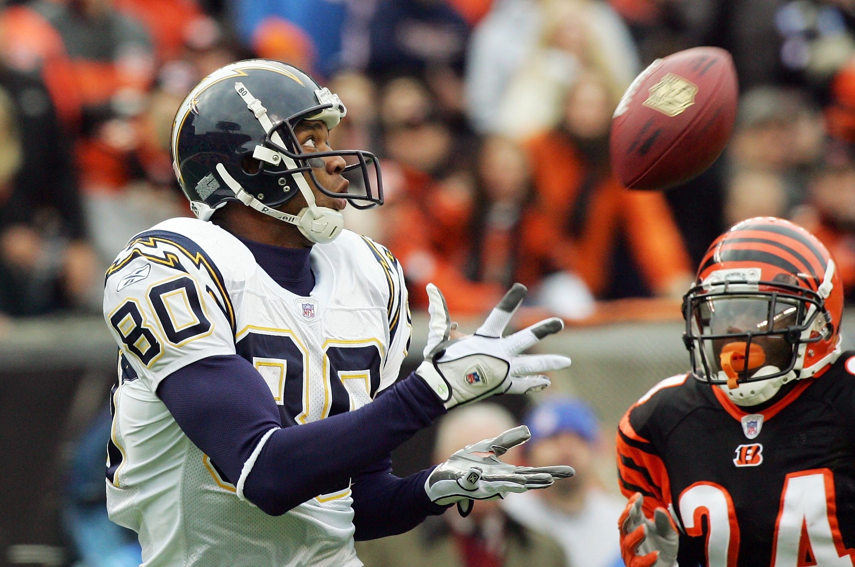 CINCINNATI - NOVEMBER 12:  Malcolm Floyd #80 San Diego Chargers cathes the ball in front of Deltha O'Neal #24 of the Cincinnati Bengals during the NFL game on November 12, 2006 at Paul Brown Stadium in Cincinnati, Ohio.  (Photo by Jim McIsaac/Getty Images