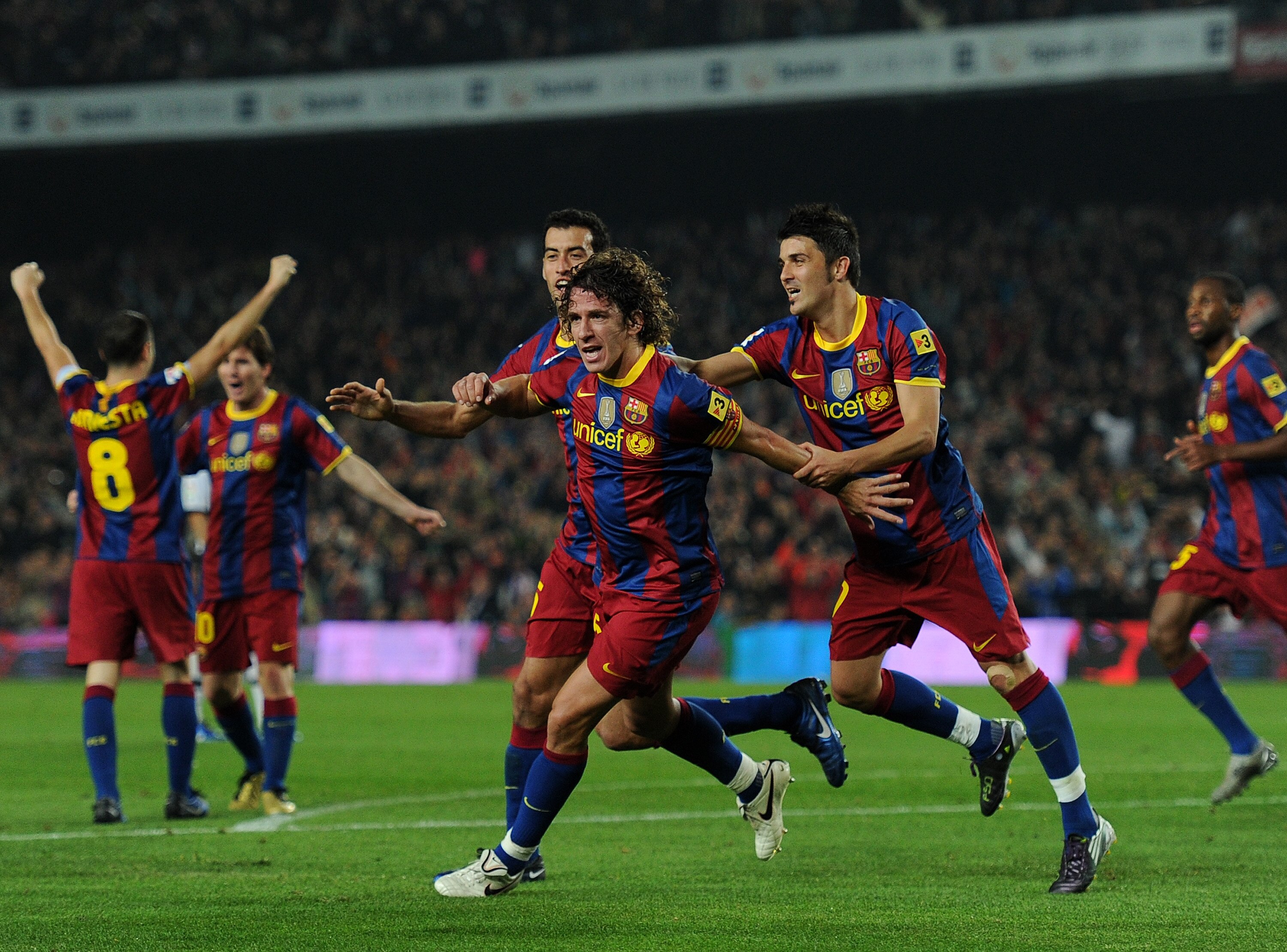 BARCELONA, SPAIN - OCTOBER 16:  Carles Puyol (C) of Barcelona celebrates scoring his sides second goal with his teammates Sergio Busquets (L) and David Villa (R) during the La Liga match between Barcelona and Valencia at the Camp Nou stadium on October 16