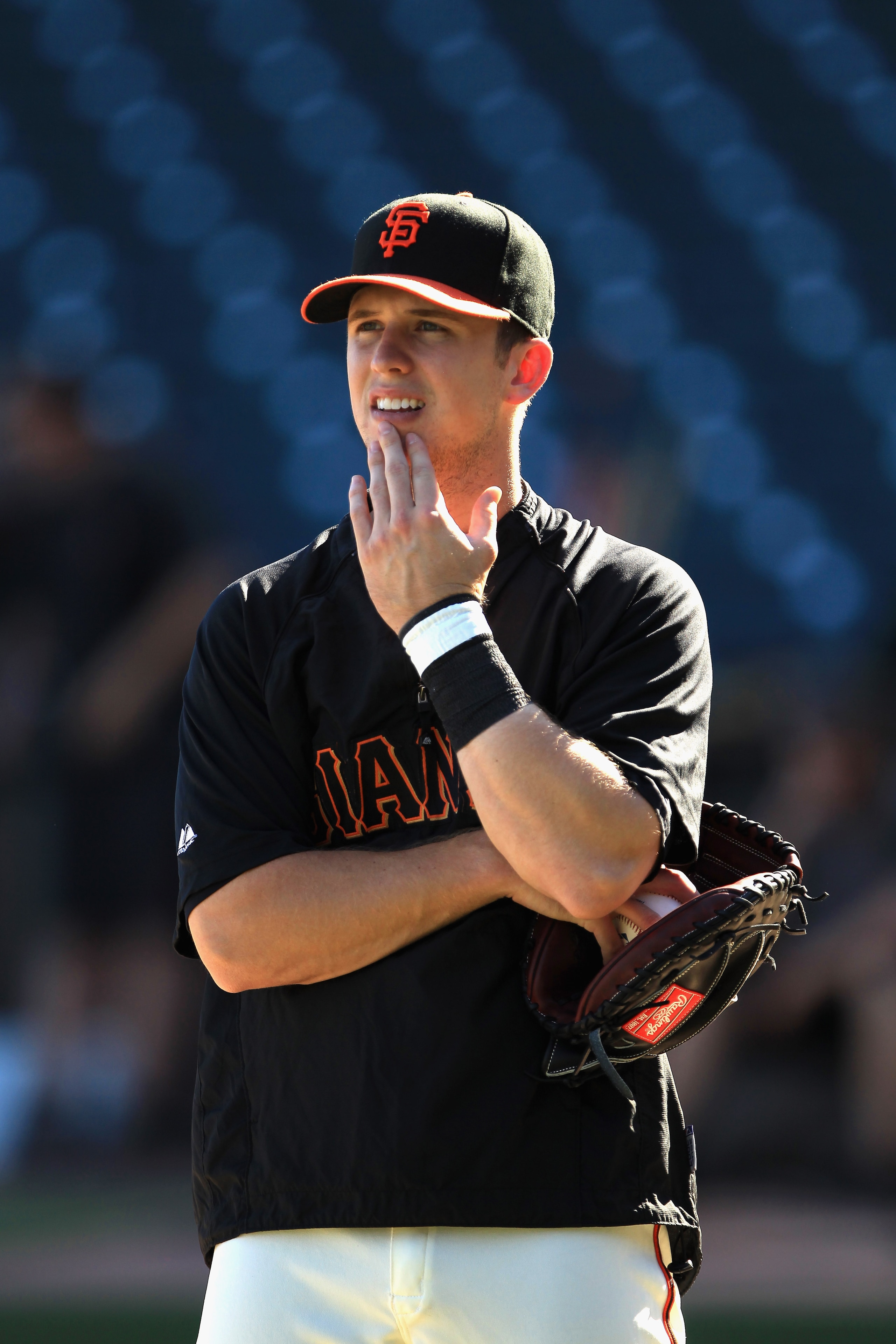 SAN FRANCISCO - OCTOBER 13:  Buster Posey #28 of the San Francisco Giants watches his teammates warm up during a workout session in preparation for the National League Championship Series at AT&T Park on October 13, 2010 in San Francisco, California.  (Ph