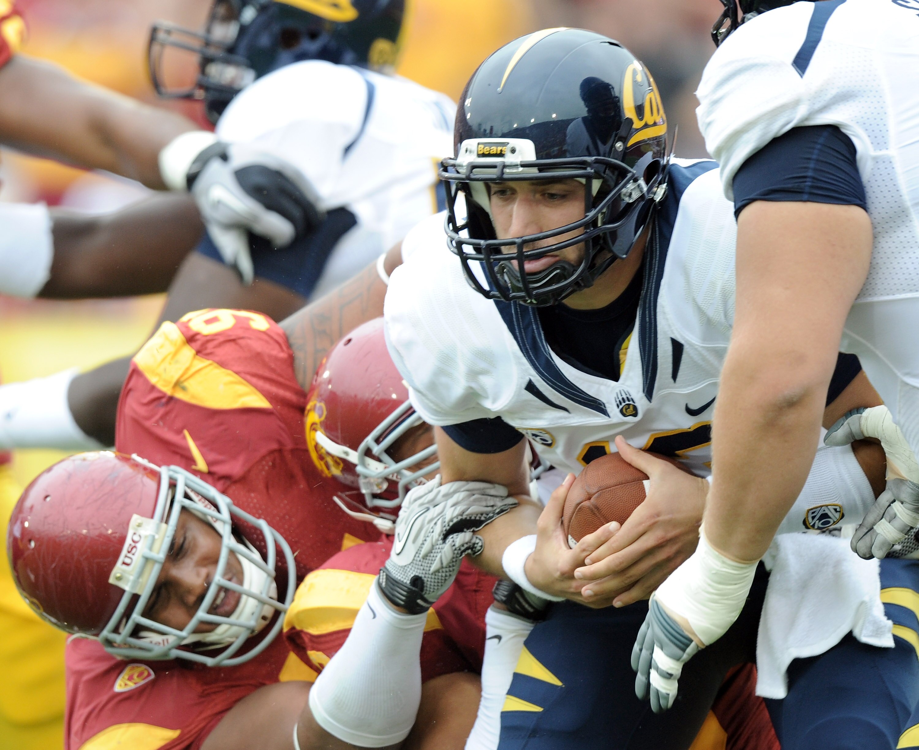 LOS ANGELES, CA - OCTOBER 16:  Kevin Riley #13 of the California Golden Bears is sacked by Jurrell Casey #91 and Nick Perry #8 of the USC Trojans during the first quarter at Los Angeles Memorial Coliseum on October 16, 2010 in Los Angeles, California.  (P