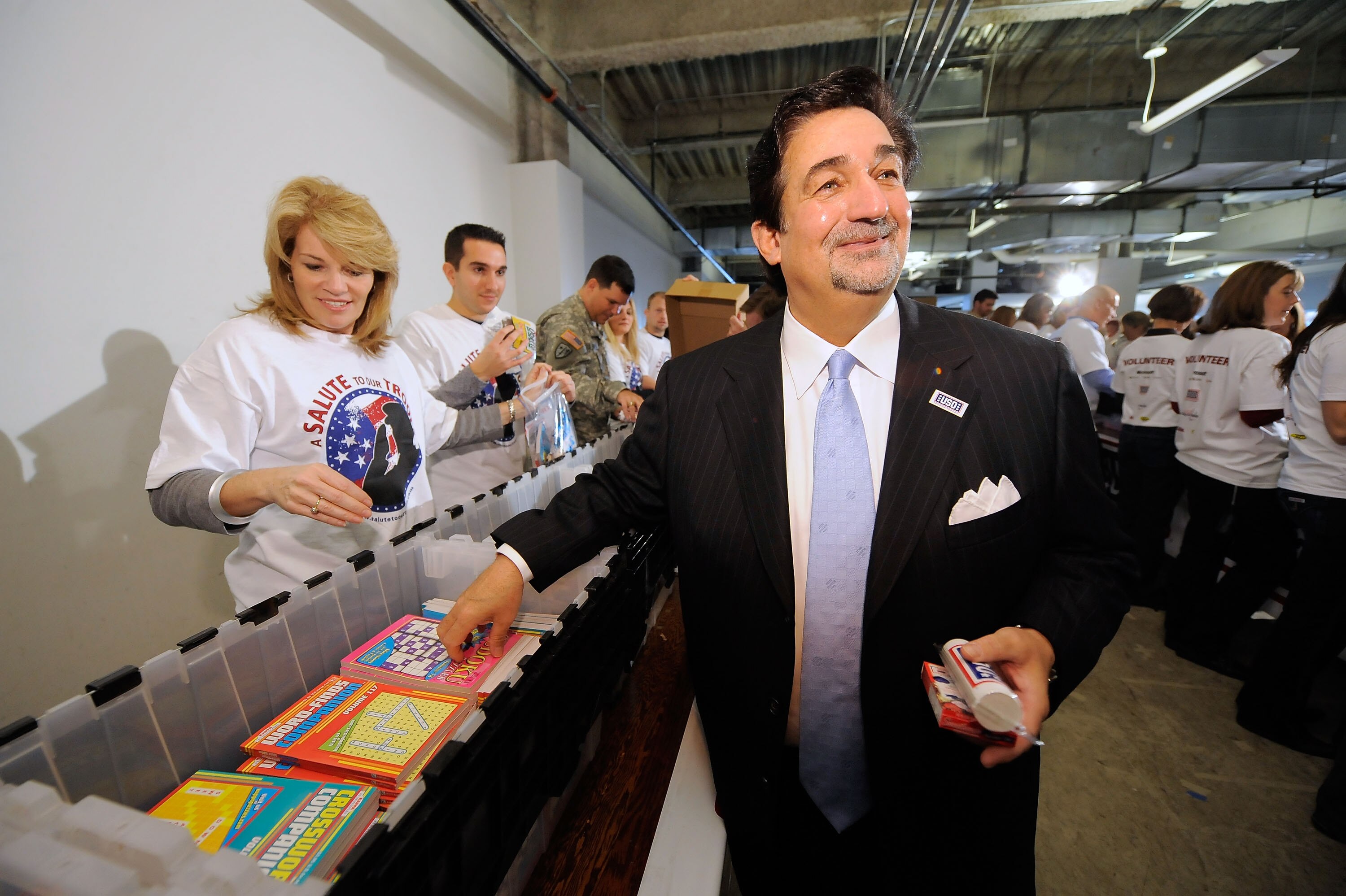 ARLINGTON, VA - NOVEMBER 09:  Teresa Carlson, Vice President US Federal Government Microsoft Corporation and Ted Leonsis, owner of the Washington Capitols joins volunteers in creating care packages for active duty US Military personal serving in Iraq and 