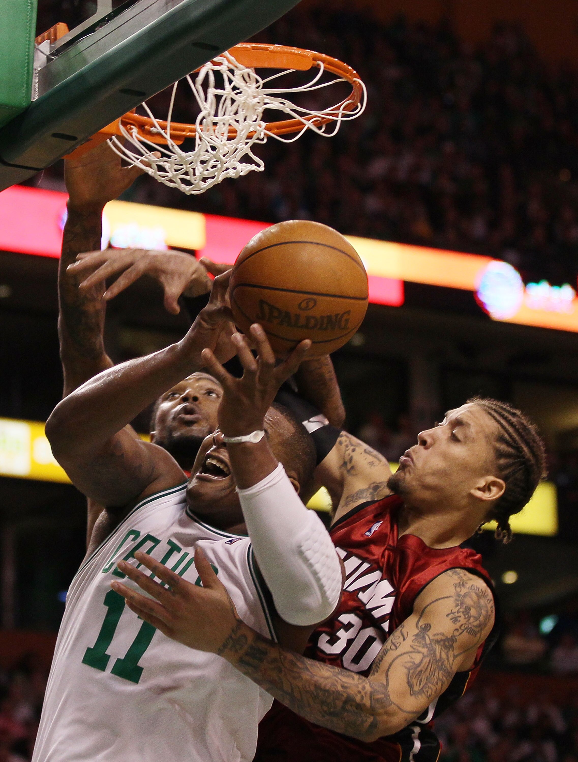 BOSTON - APRIL 20:  Glen Davis #11 of the Boston Celtics fights for the ball with Udonis Haslem #40 and Michael Beasley #30 of the Miami Heat during Game Two of the Eastern Conference Quarterfinals of the 2010 NBA playoffs at the TD Garden on April 20, 20