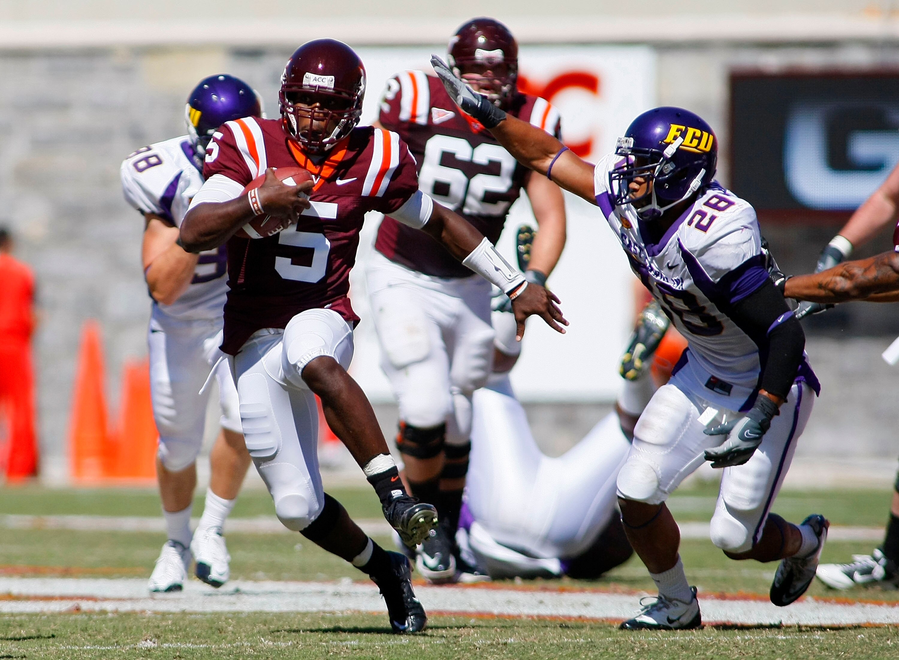 BLACKSBURG, VA - SEPTEMBER 18:  Quarterback Tyrod Taylor #5 of the Virginia Tech hokies runs with the ball as  linebacker Matt Thompson #28 of the East Carolina Pirates defends at Lane Stadium on September 18, 2010 in Blacksburg, Virginia.  (Photo by Geof