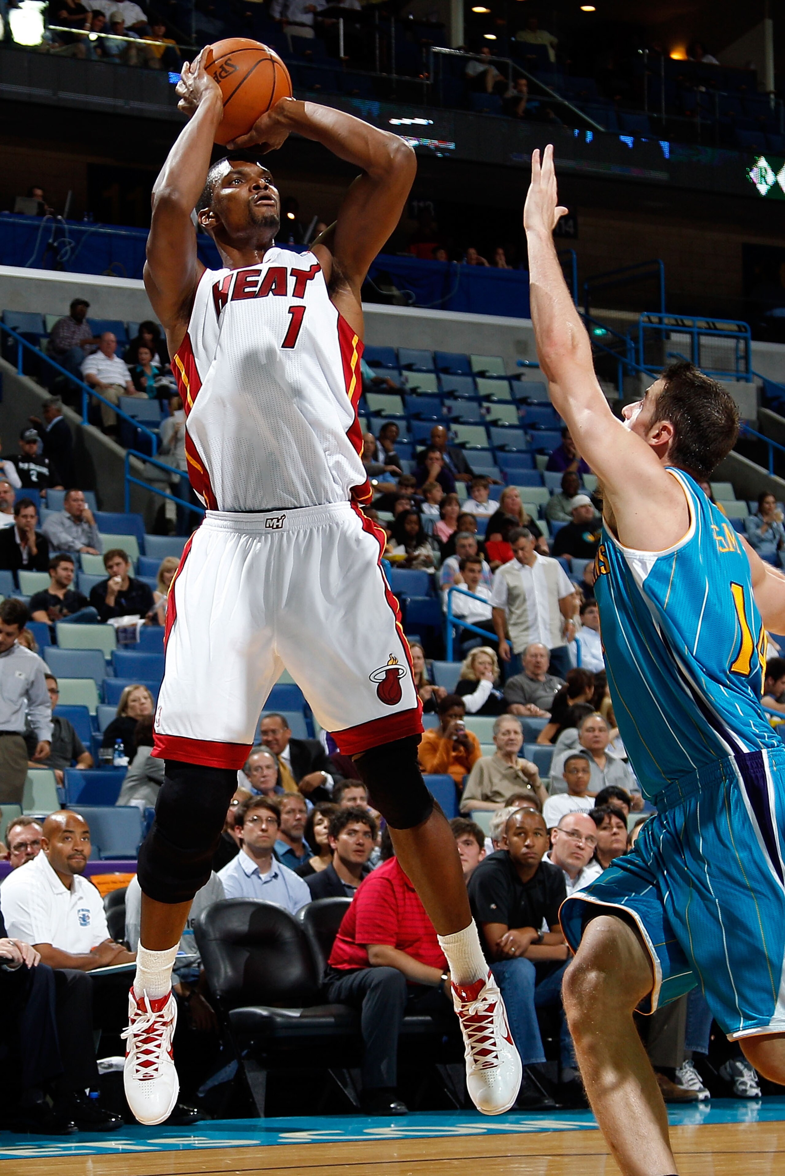 NEW ORLEANS - OCTOBER 13:  Chris Bosh #1 of the Miami Heat shoots the ball over Jason Smithe #14 of the New Orleans Hornets at the New Orleans Arena on October 13, 2010 in New Orleans, Louisiana.  NOTE TO USER: User expressly acknowledges and agrees that,