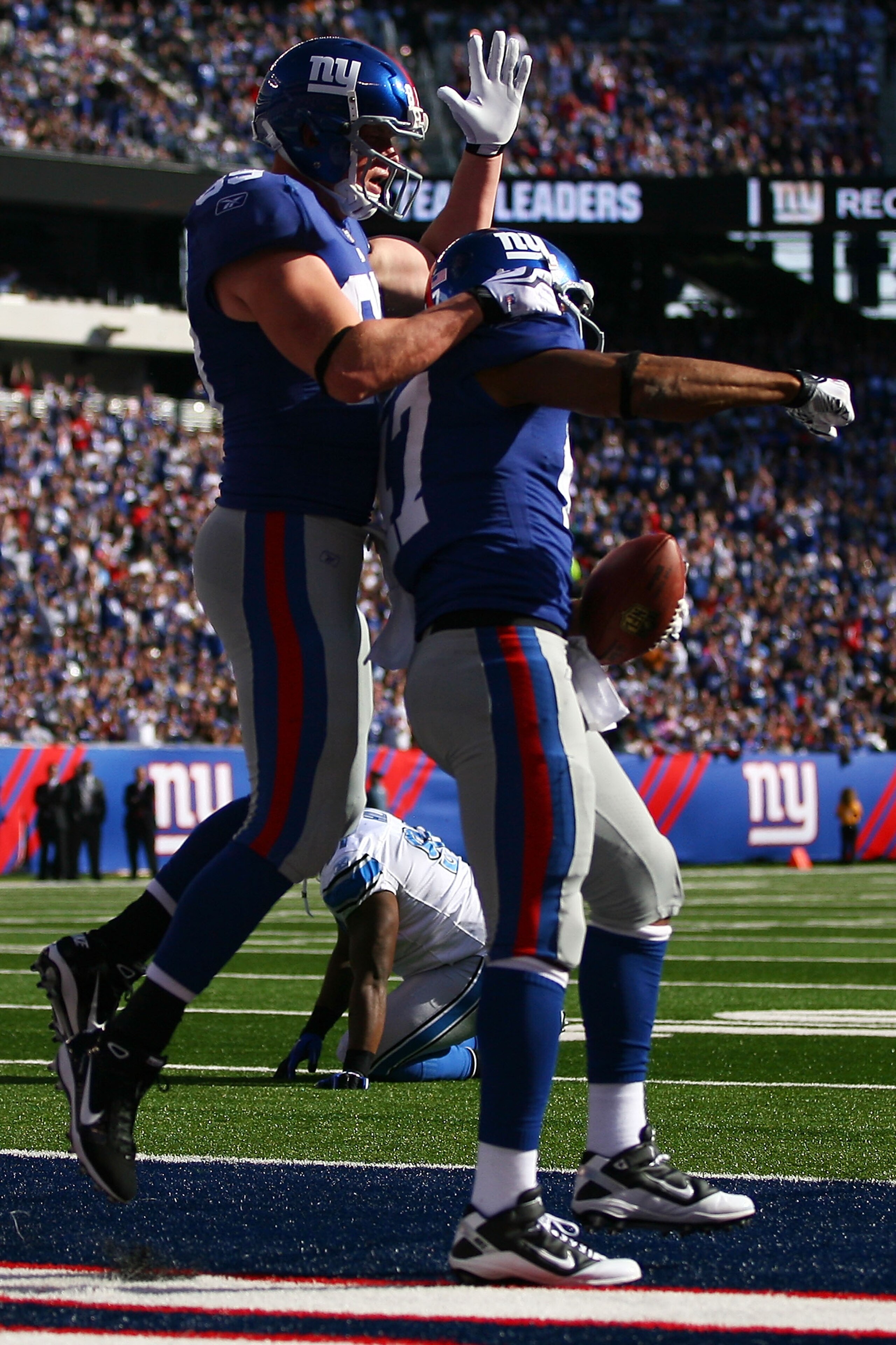 EAST RUTHERFORD, NJ - OCTOBER 17:  Kevin Boss #89 (R) and Travis Beckum #47 of the New York Giants celebrate after Beckum's third quarter touch down against the Detroit Lions at New Meadowlands Stadium on October 17, 2010 in East Rutherford, New Jersey.