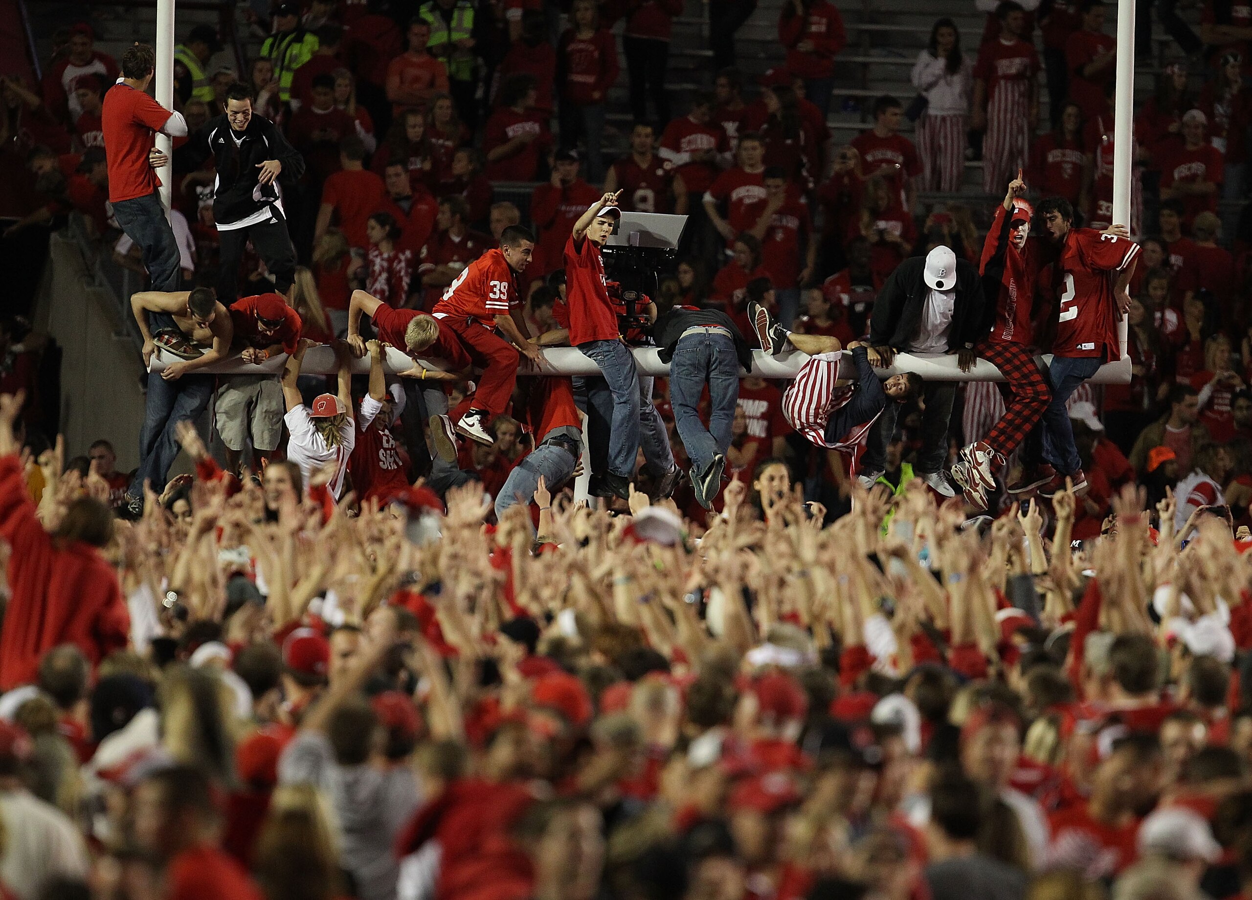 MADISON, WI - OCTOBER 16: Fans of the Wisconsin Badgers storm the field and climb the goal post after a win over the Ohio State Buckeyes at Camp Randall Stadium on October 16, 2010 in Madison, Wisconsin. Wisconsin defeated Ohio State 31-18. (Photo by Jona