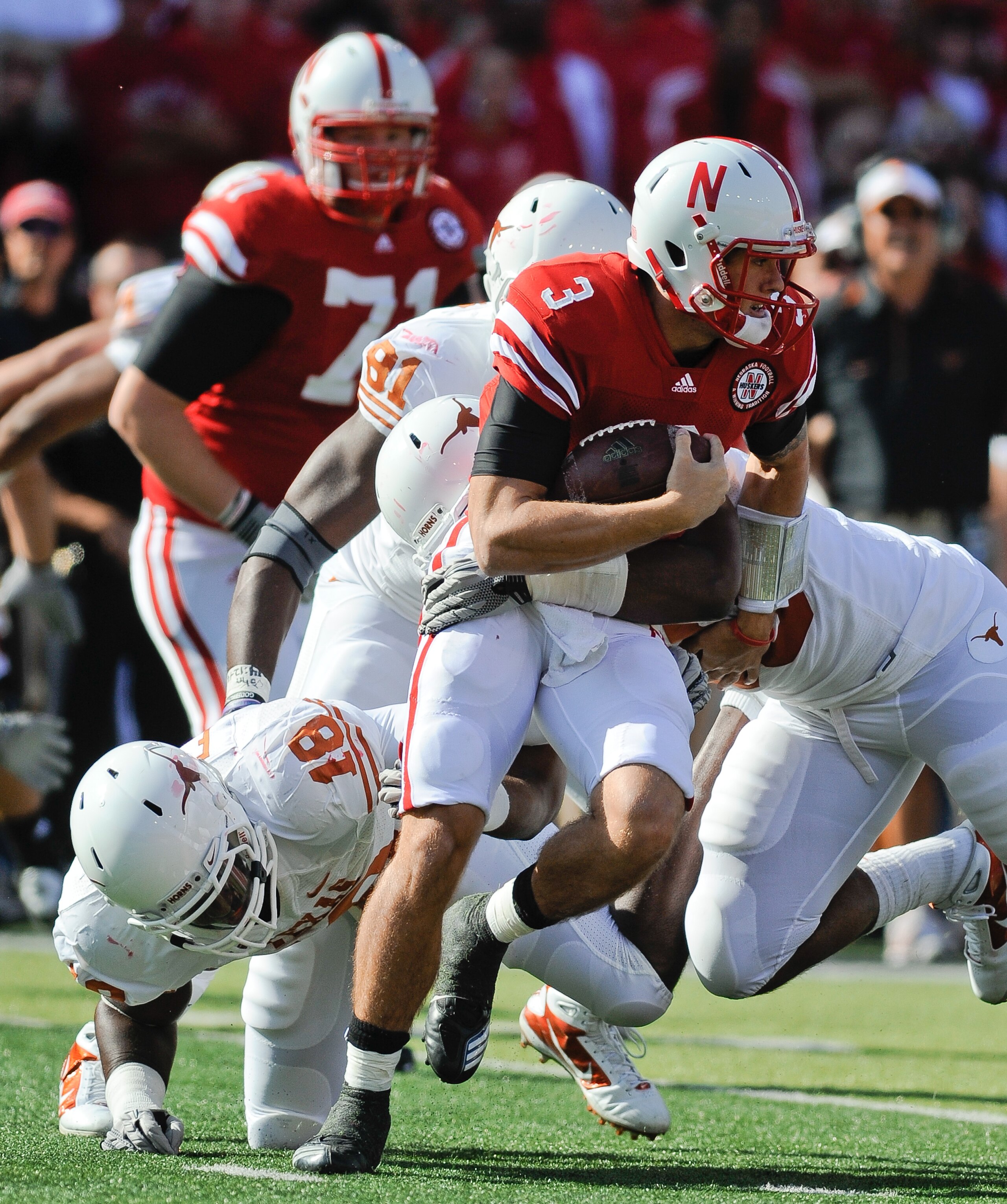 LINCOLN, NE - OCTOBER 16: Quarterback Taylor Martinez #3 of the Nebraska Cornhuskers runs from the grasp of Texas Longhorns linebacker Emmanuel Acho #18 during first half action of their game at Memorial Stadium on October 16, 2010 in Lincoln, Nebraska. T LINCOLN, NE - OCTOBER 16: Quarterback Taylor Martinez #3 of the Nebraska Cornhuskers runs from the grasp of Texas Longhorns linebacker Emmanuel Acho #18 during first half action of their game at Memorial Stadium on October 16, 2010 in Lincoln, Nebraska. T