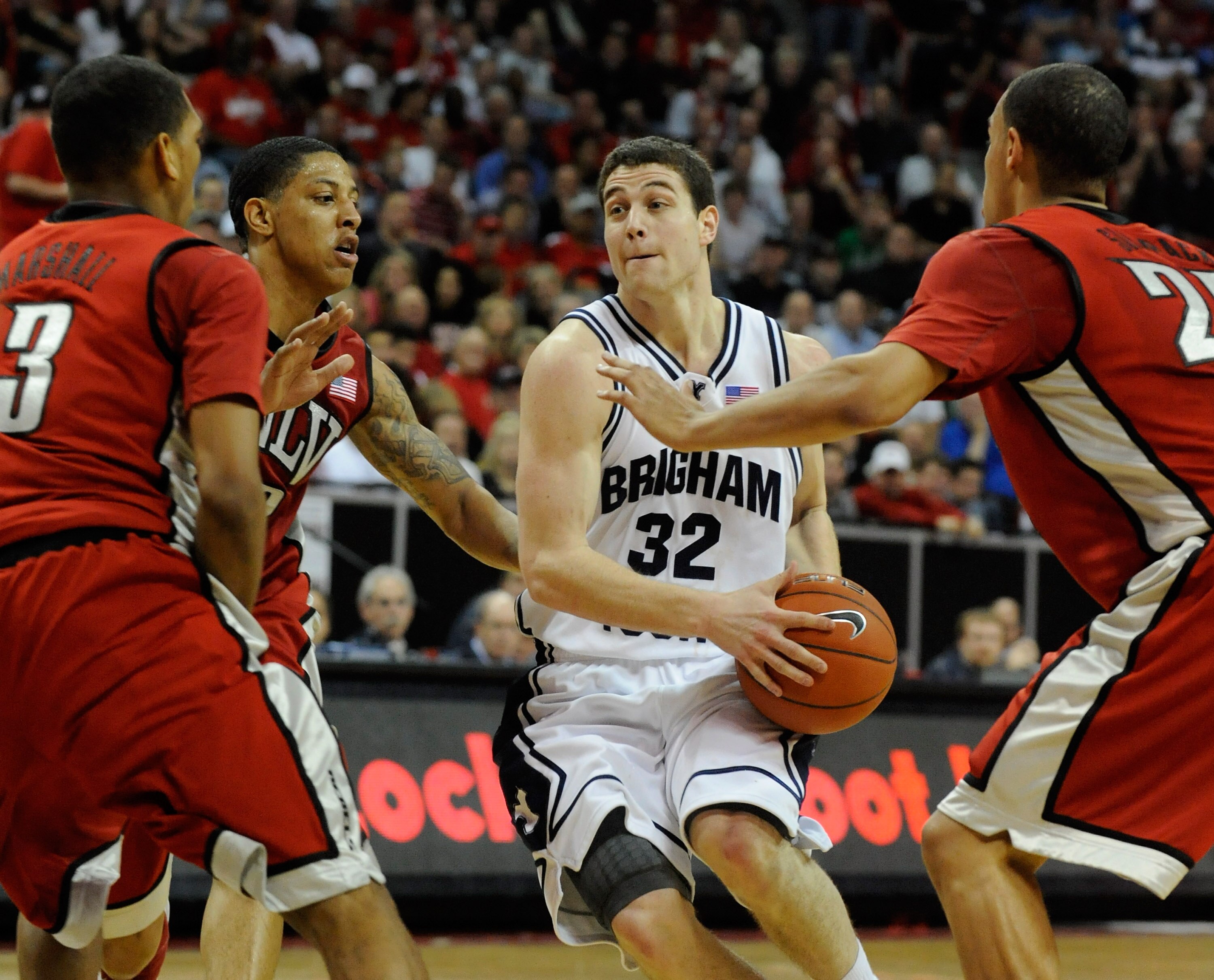 LAS VEGAS - MARCH 12:  Jimmer Fredette #32 of the Brigham Young University Cougars cuts through UNLV defenders (L-R) Anthony Marshall #3, Tre'Von Willis #33 and Chace Stanback #22 during a semifinal game of the Conoco Mountain West Conference Basketball t