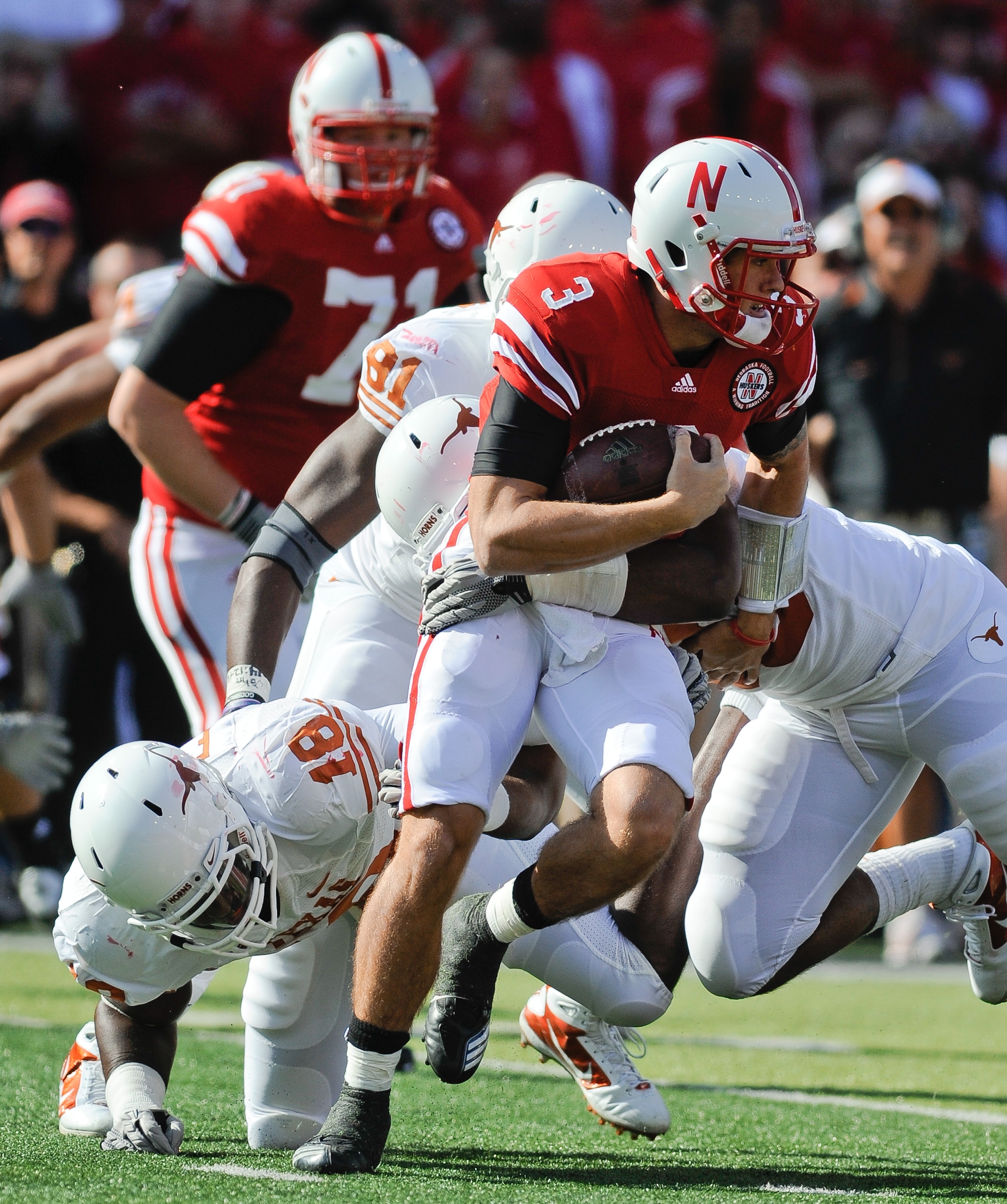 LINCOLN, NE - OCTOBER 16: Quarterback Taylor Martinez #3 of the Nebraska Cornhuskers runs from the grasp of Texas Longhorns linebacker Emmanuel Acho #18 during first half action of their game at Memorial Stadium on October 16, 2010 in Lincoln, Nebraska. T LINCOLN, NE - OCTOBER 16: Quarterback Taylor Martinez #3 of the Nebraska Cornhuskers runs from the grasp of Texas Longhorns linebacker Emmanuel Acho #18 during first half action of their game at Memorial Stadium on October 16, 2010 in Lincoln, Nebraska. T