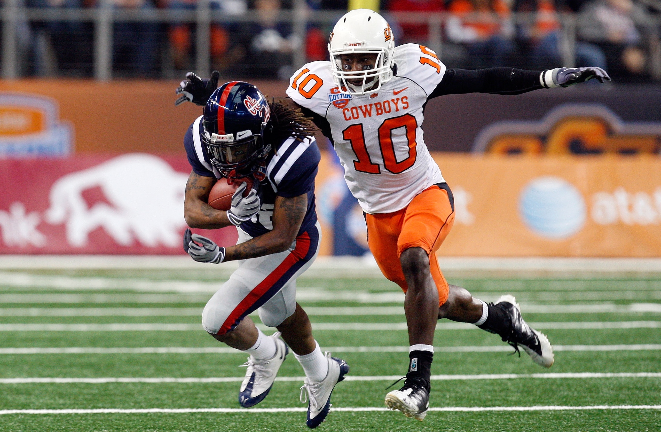 ARLINGTON, TX - JANUARY 02:  Dexter McCluster #22 of the Mississippi Rebels runs the ball against Markelle Martin #10 of the Oklahoma State Cowboys during the AT&T Cotton Bowl on January 2, 2010 at Cowboys Stadium in Arlington, Texas.  (Photo by Ronald Ma