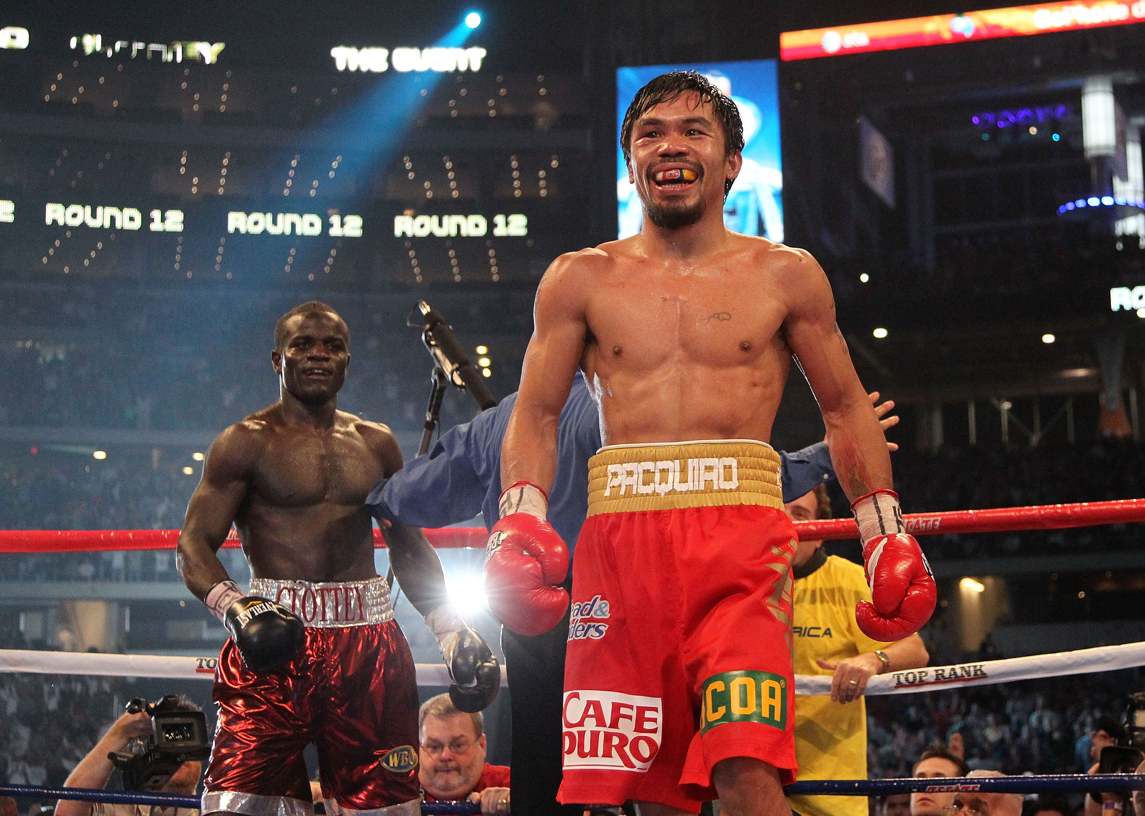 ARLINGTON, TX - MARCH 13:  (R-L) Manny Pacquiao of the Philippines smiles in the ring after the final bell against Joshua Clottey of Ghana during the WBO welterweight title fight at Cowboys Stadium on March 13, 2010 in Arlington, Texas. Pacquiao defeated