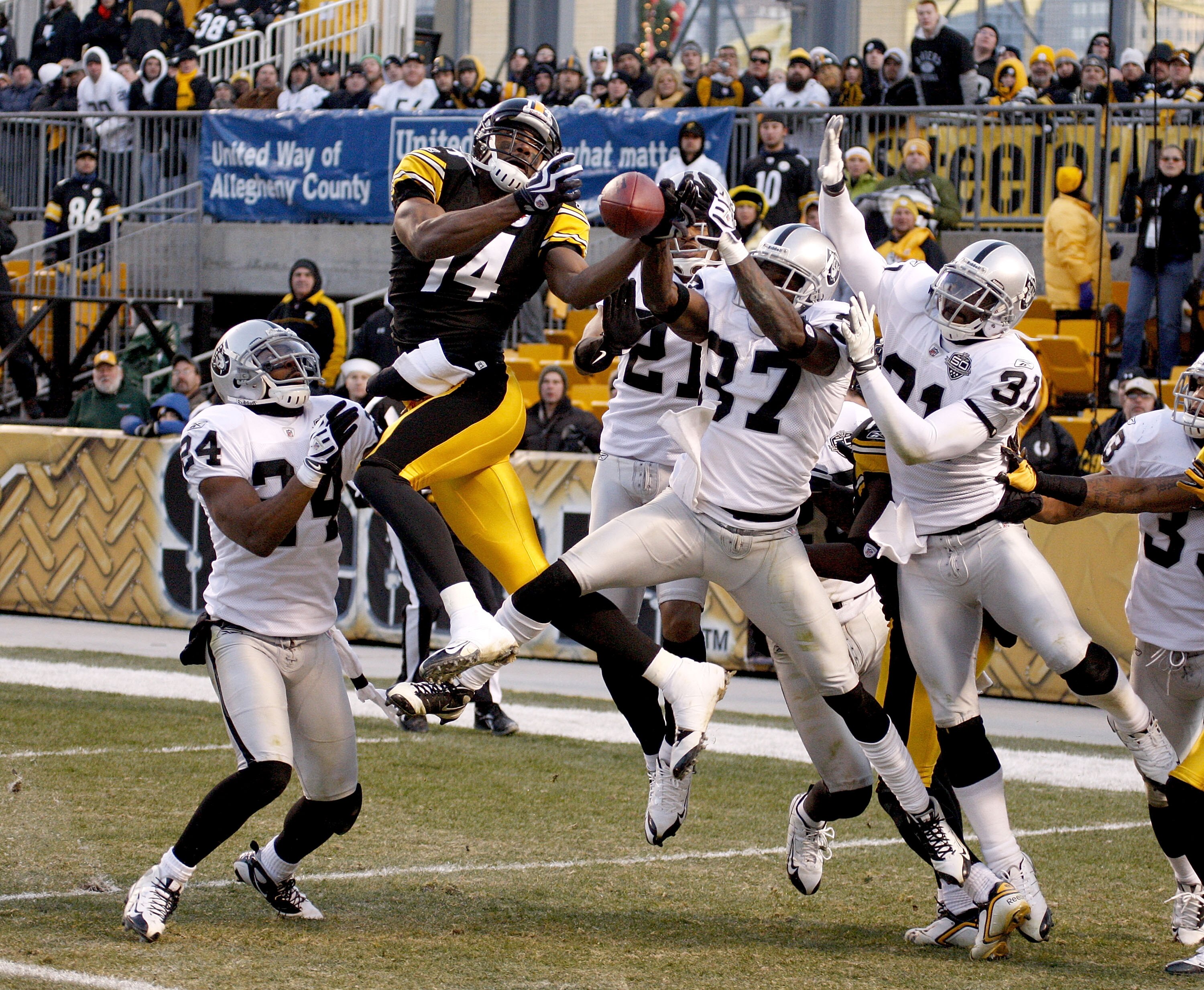 PITTSBURGH - DECEMBER 06:  Limas Sweek #14 of the Pittsburgh Steelers tries to come down with a hail mary pass with no time on the clock between Michael Huff #24, Chris Johnson #37 and Hiram Eugene #31 of the Oakland Raiders on December 6, 2009 at Heinz F