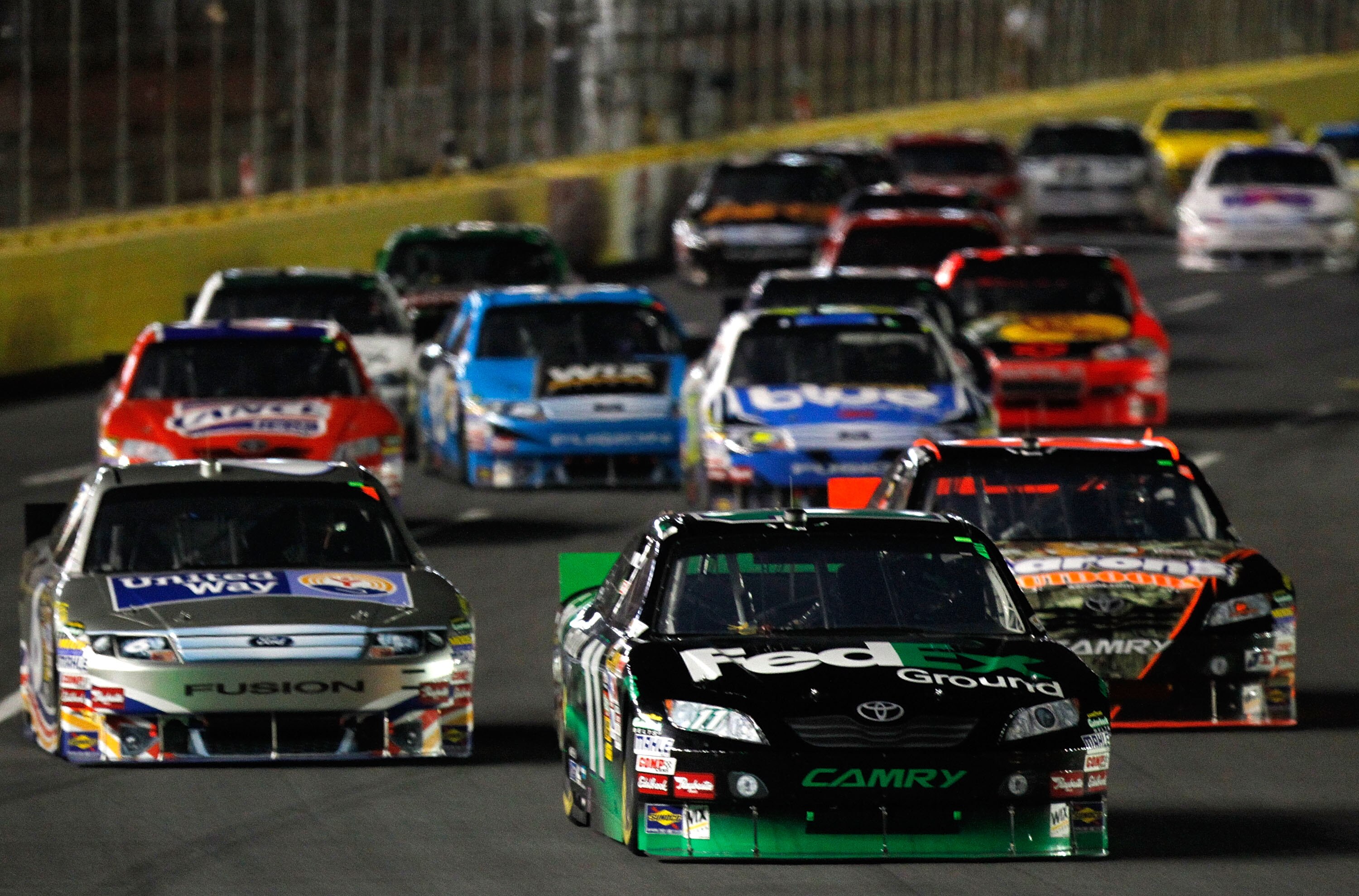 CONCORD, NC - OCTOBER 16: Denny Hamlin, driver of the #11 FedEx Ground Toyota, leads a group of cars during the NASCAR Sprint Cup Series Bank of America 500 at Charlotte Motor Speedway on October 16, 2010 in Concord, North Carolina.  (Photo by Geoff Burke