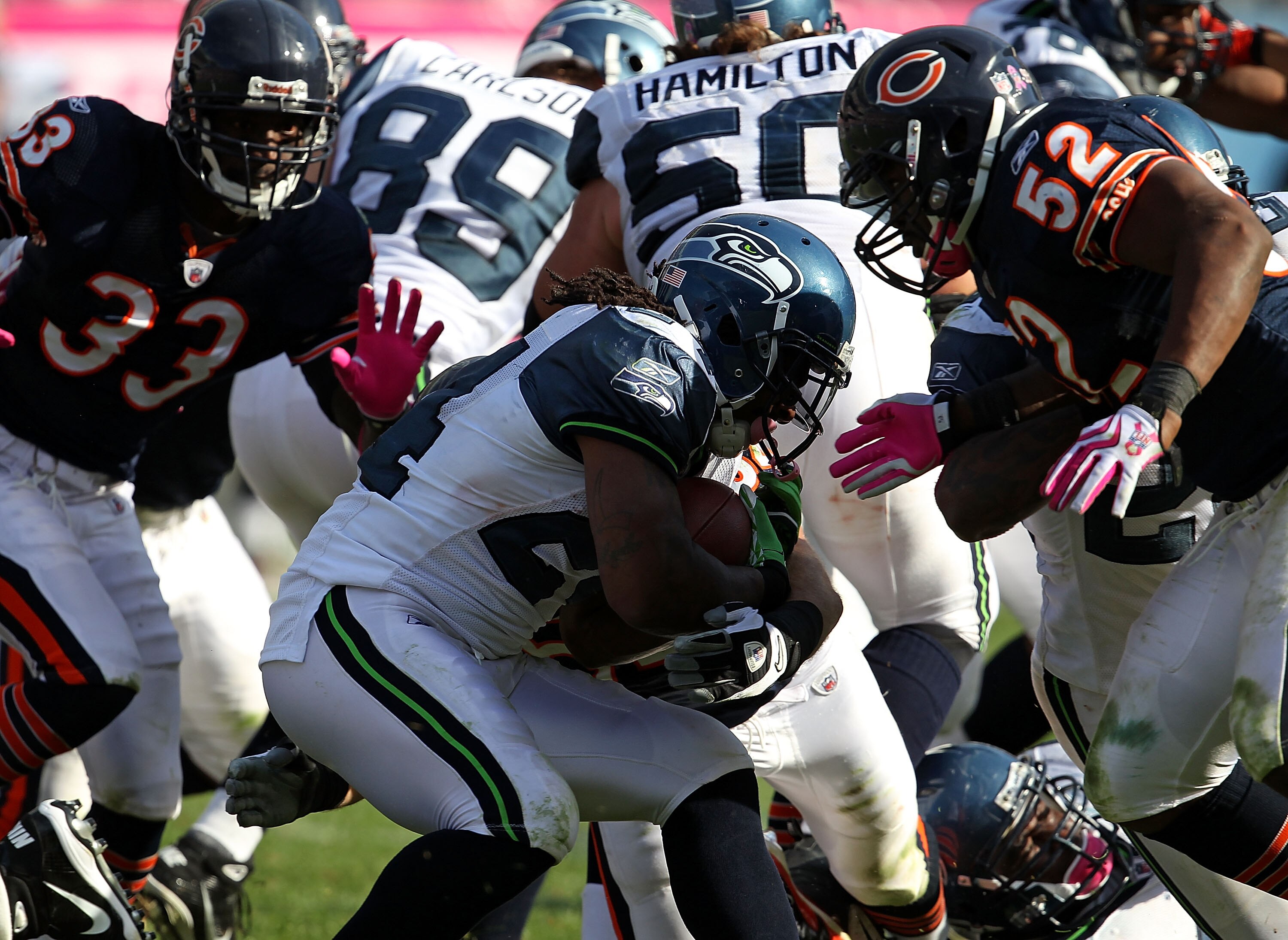 CHICAGO - OCTOBER 17: Marshawn Lynch #24 of the Seattle Seahawks runs against Charles Tillman #33 and Brian Iwuh #52 of the Chicago Bears at Soldier Field on October 17, 2010 in Chicago, Illinois. The Seahawks defeated the Bears 23-20. (Photo by Jonathan