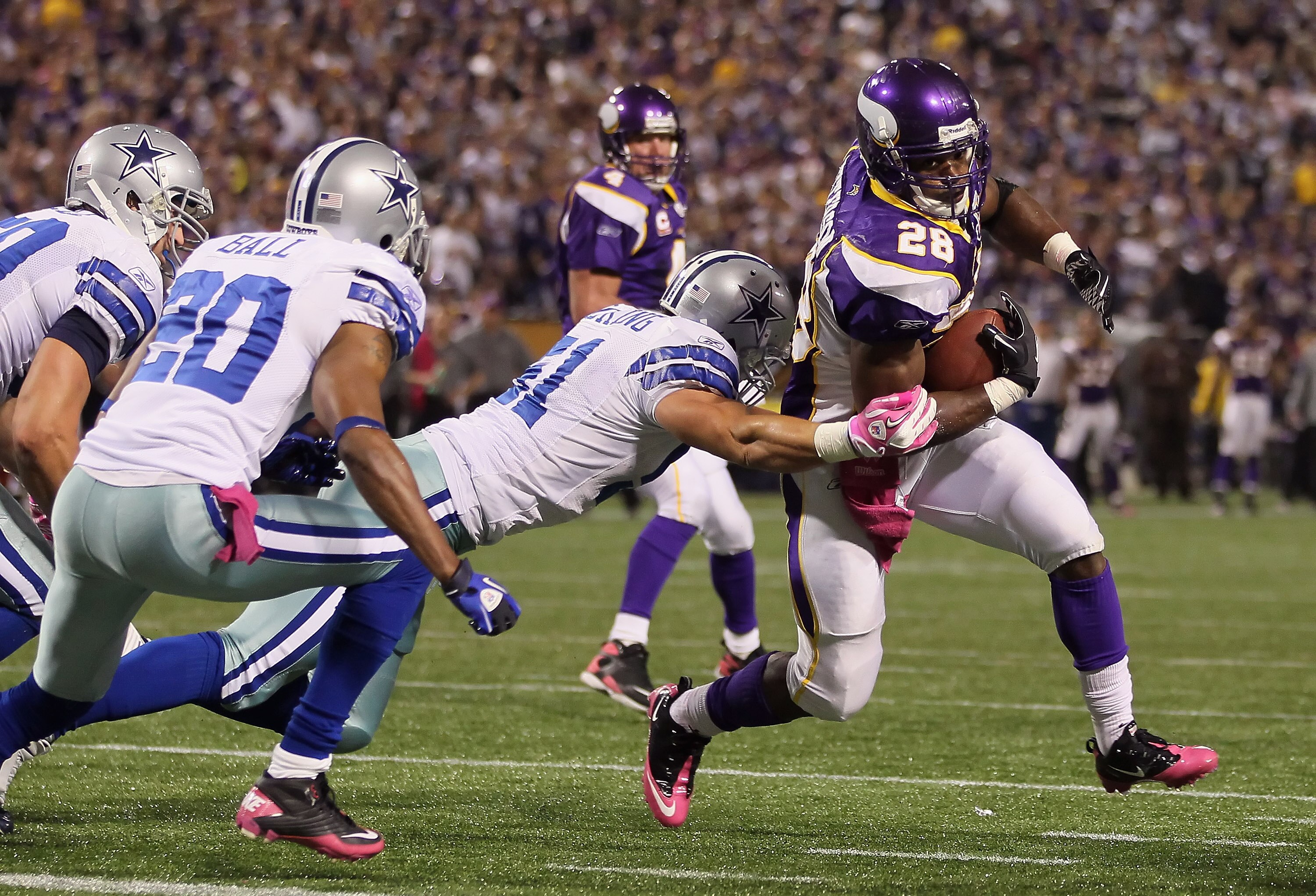 MINNEAPOLIS - OCTOBER 17:  Running back Adrian Peterson #29 of the Minnesota Vikings breaks a tackle from Keith Brooking #51 of the Dallas Cowboys for a touchdown during the third quarter at Mall of America Field on October 17, 2010 in Minneapolis, Minnes