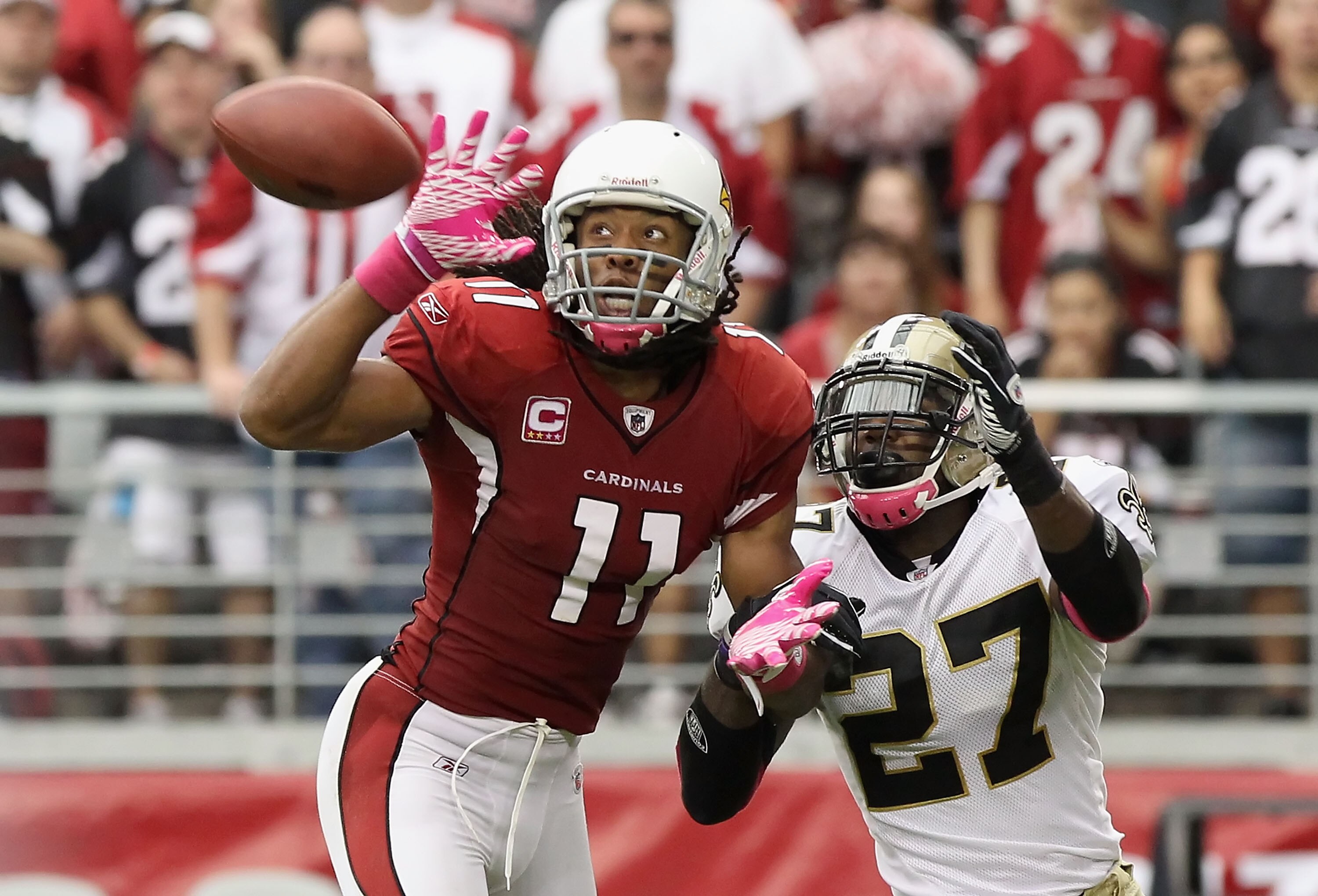 GLENDALE, AZ - OCTOBER 10:  Wide receiver Larry Fitzgerald #11 of the Arizona Cardinals attempts to catch a pass under pressure from Malcolm Jenkins #27 of the New Orleans Saints during the NFL game at the University of Phoenix Stadium on October 10, 2010