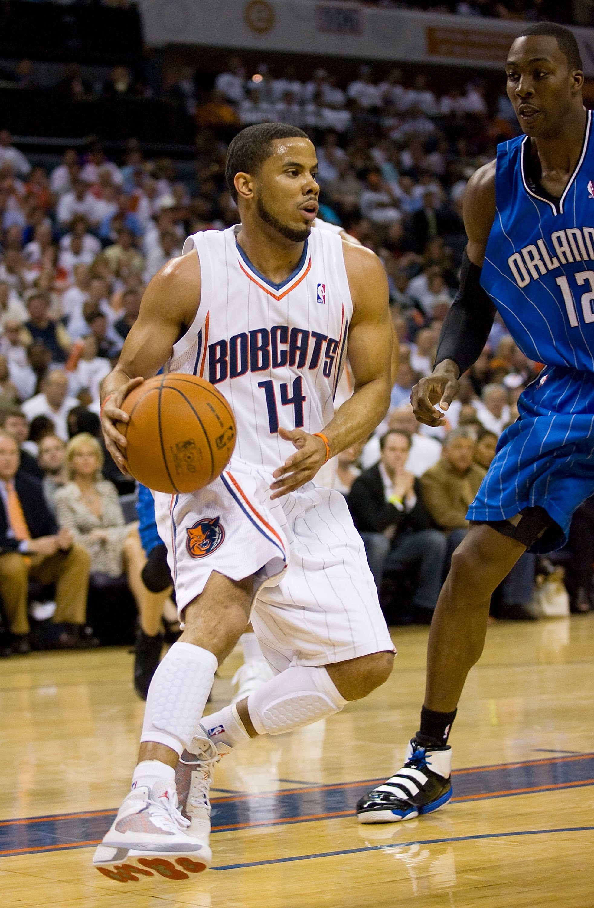 CHARLOTTE, NC - APRIL 26: D.J. Augustin #14 of the Charlotte Bobcats drives the baseline past Dwight Howard #12 of the Orlando Magic at Time Warner Cable Arena on April 26, 2010 in Charlotte, North Carolina.  The Magic defeated the Bobcats 99-90 to comple
