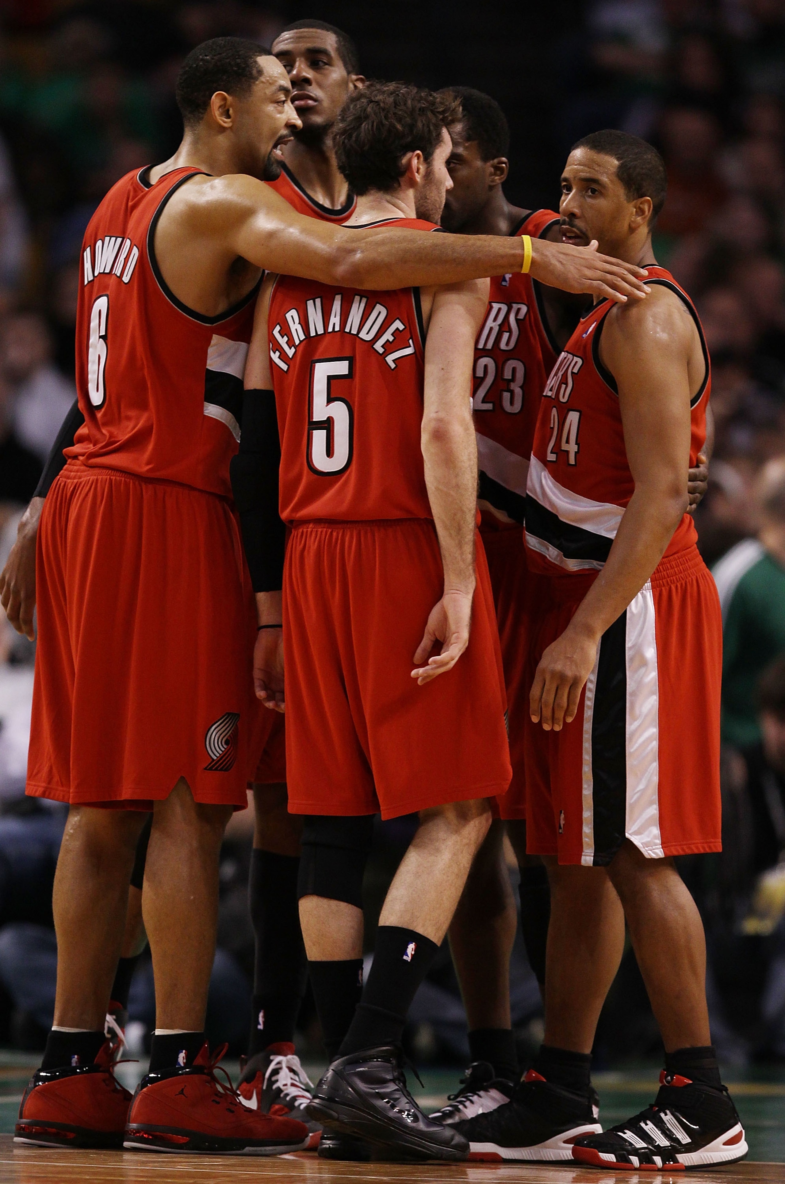 BOSTON - JANUARY 22:  Juwan Howard #6 of the Portland Trailblazers gathers teammates Rudy Fernandez #5 and Andre Miller #24 together during a break in play in the second half against the Boston Celtics at the TD Garden on January 22, 2010 in Boston, Massa
