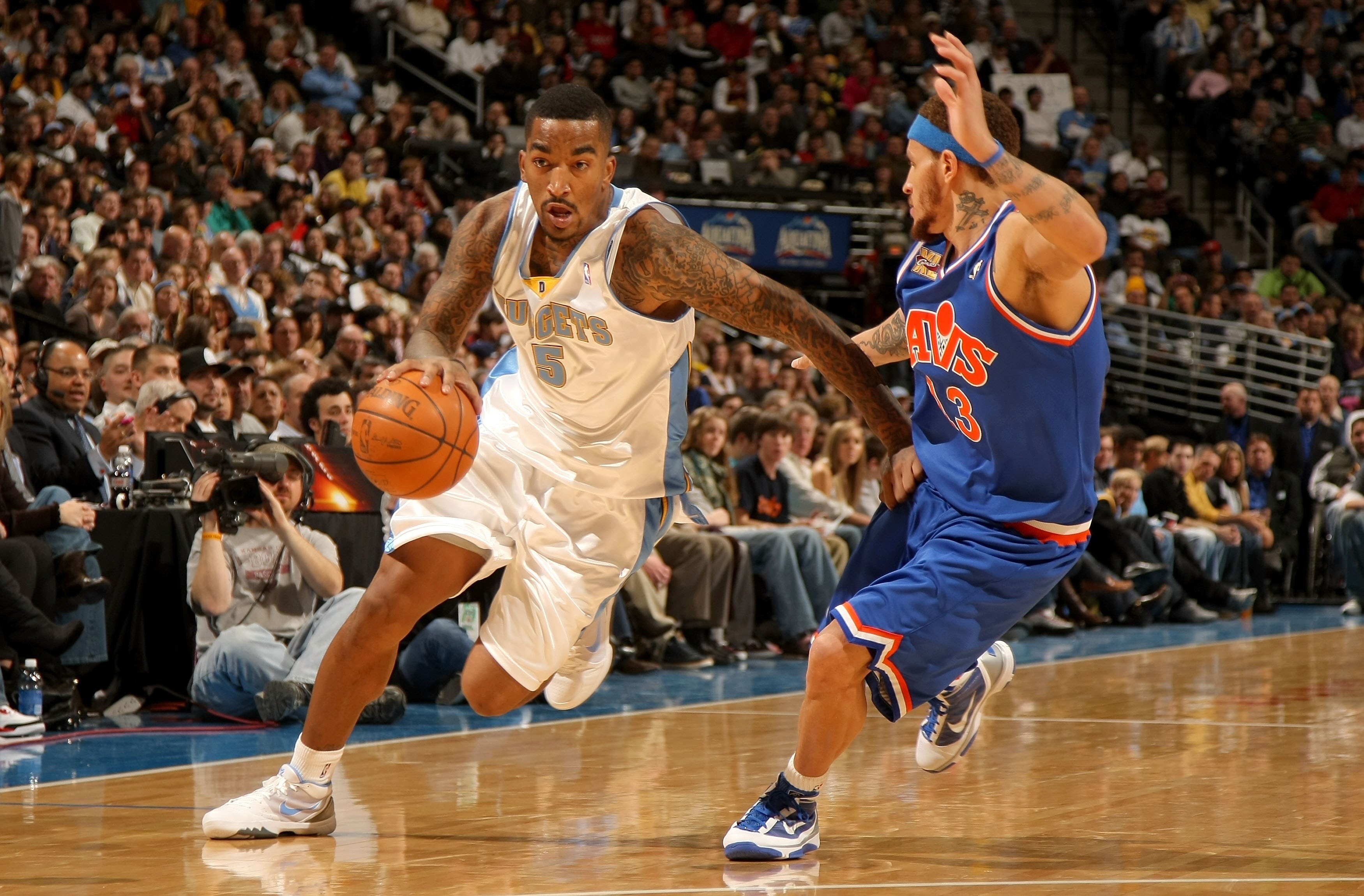 DENVER - JANUARY 08:  J.R. Smith #5 of the Denver Nuggets dribbles the ball against Delonte West #13 of the Cleveland Cavaliers during NBA action at Pepsi Center on January 8, 2010 in Denver, Colorado. The Nuggets defeated the Cavaliers 99-97. NOTE TO USE