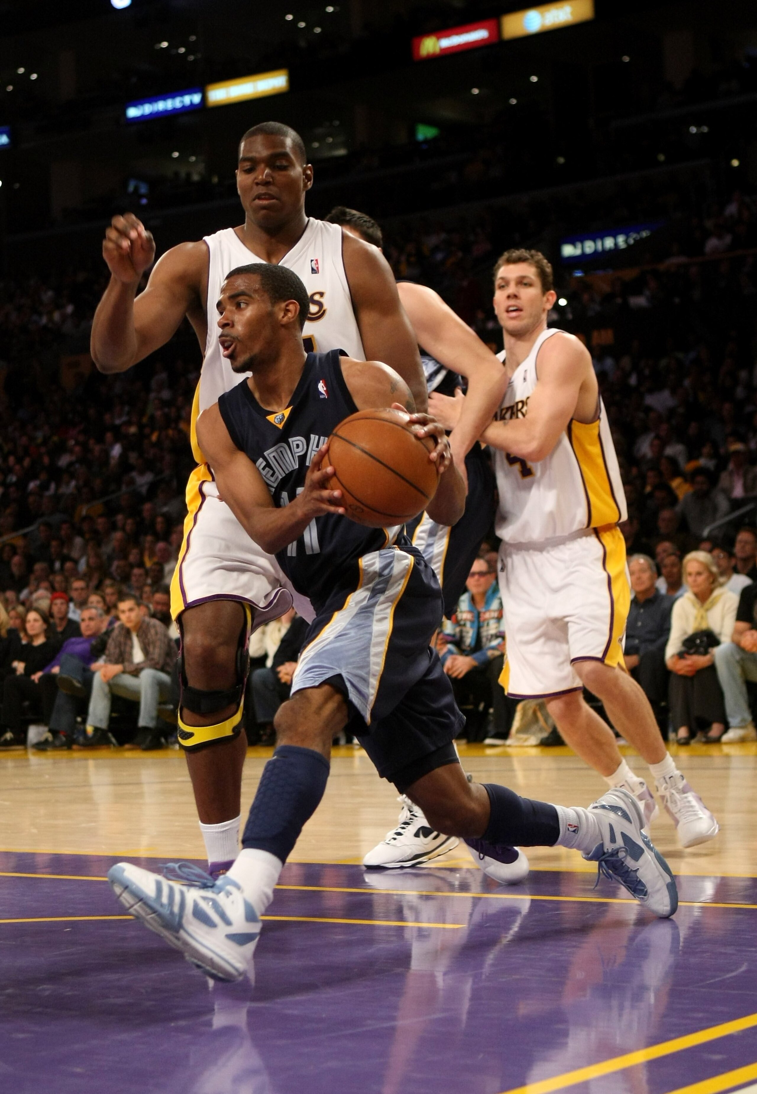 LOS ANGELES - APRIL 12:   Mike Conley #11 of the Memphis Grizzliesdrives around Andrew Bynum #17 of the Los Angeles Lakers on April 12, 2009 at Staples Center in Los Angeles, California.  The Lakers won 92-75.  NOTE TO USER: User expressly acknowledges an