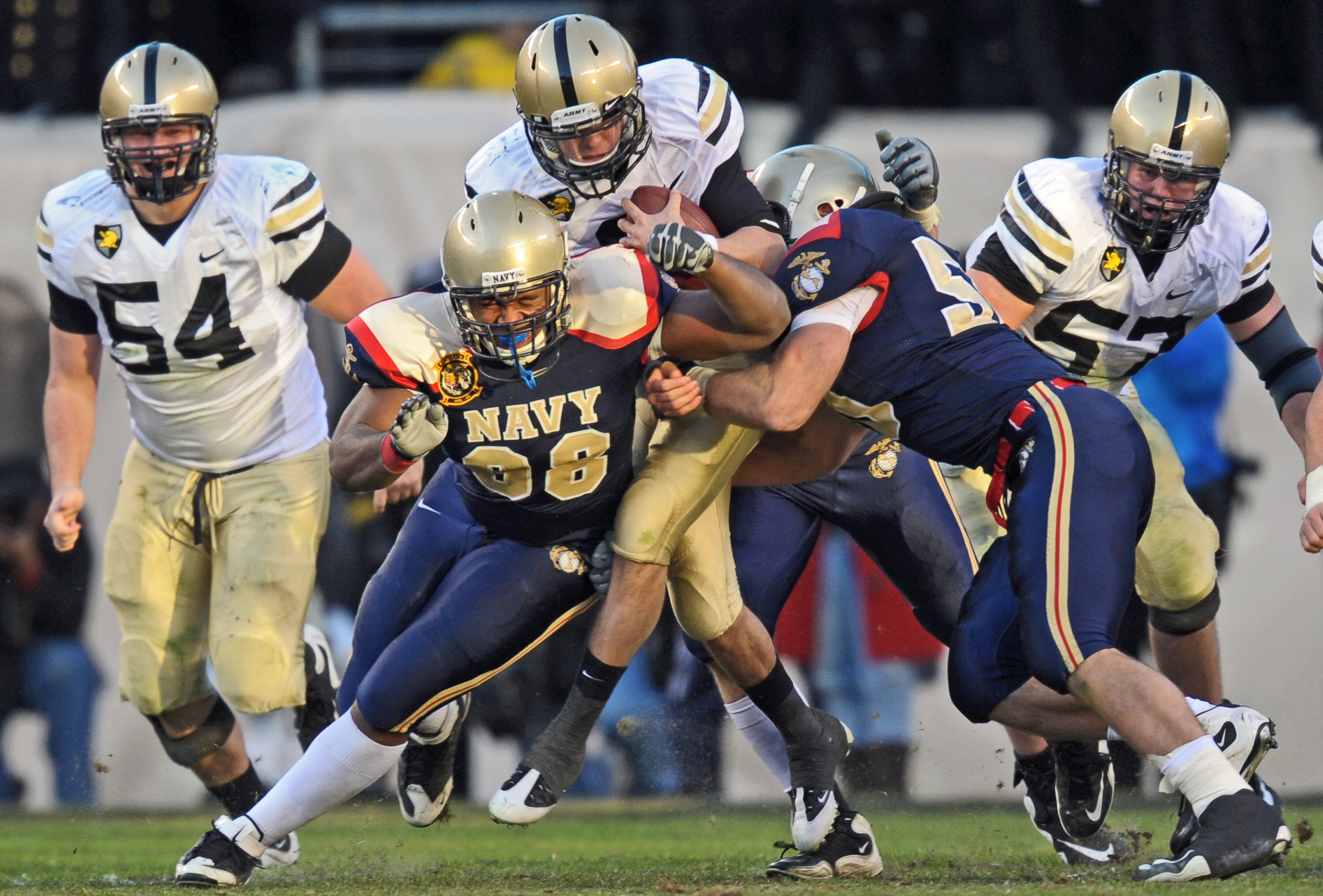 PHILADELPHIA - DECEMBER 12: Quarterback Trent Steelman #8 of  the Army Black Knights gets tackled by defensive end Jabaree Tuani #98 and linebacker Tony Haberer #50 of the Navy Midshipmen on December 12, 2009 at Lincoln Financial Field in Philadelphia, Pe