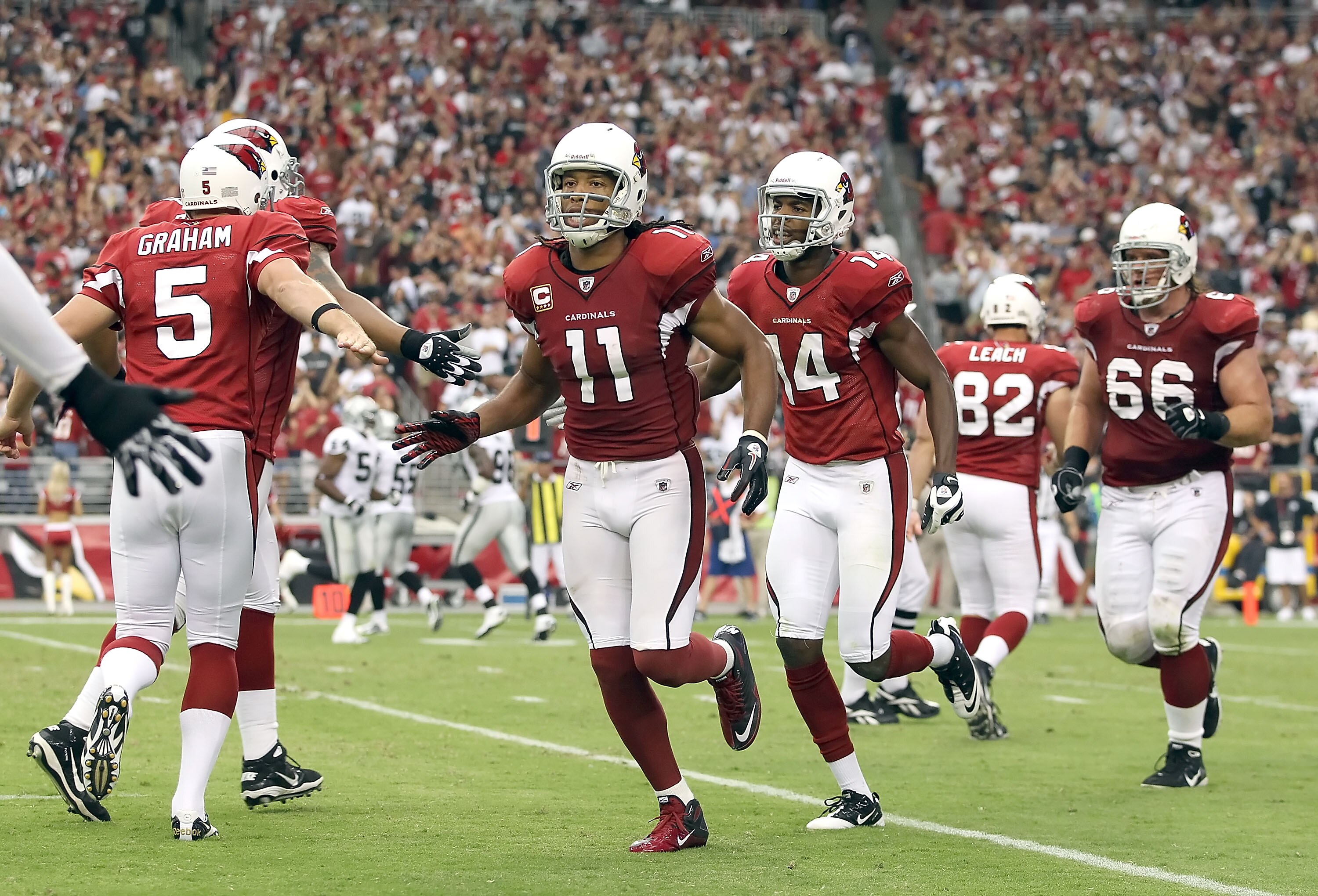 GLENDALE, AZ - SEPTEMBER 26:  Wide receiver Larry Fitzgerald #11 of the Arizona Cardinals celebrates with teammates after scoring on a 8 yard touchdown reception against the Oakland Raiders during the thrid quarter of the NFL game at the University of Pho