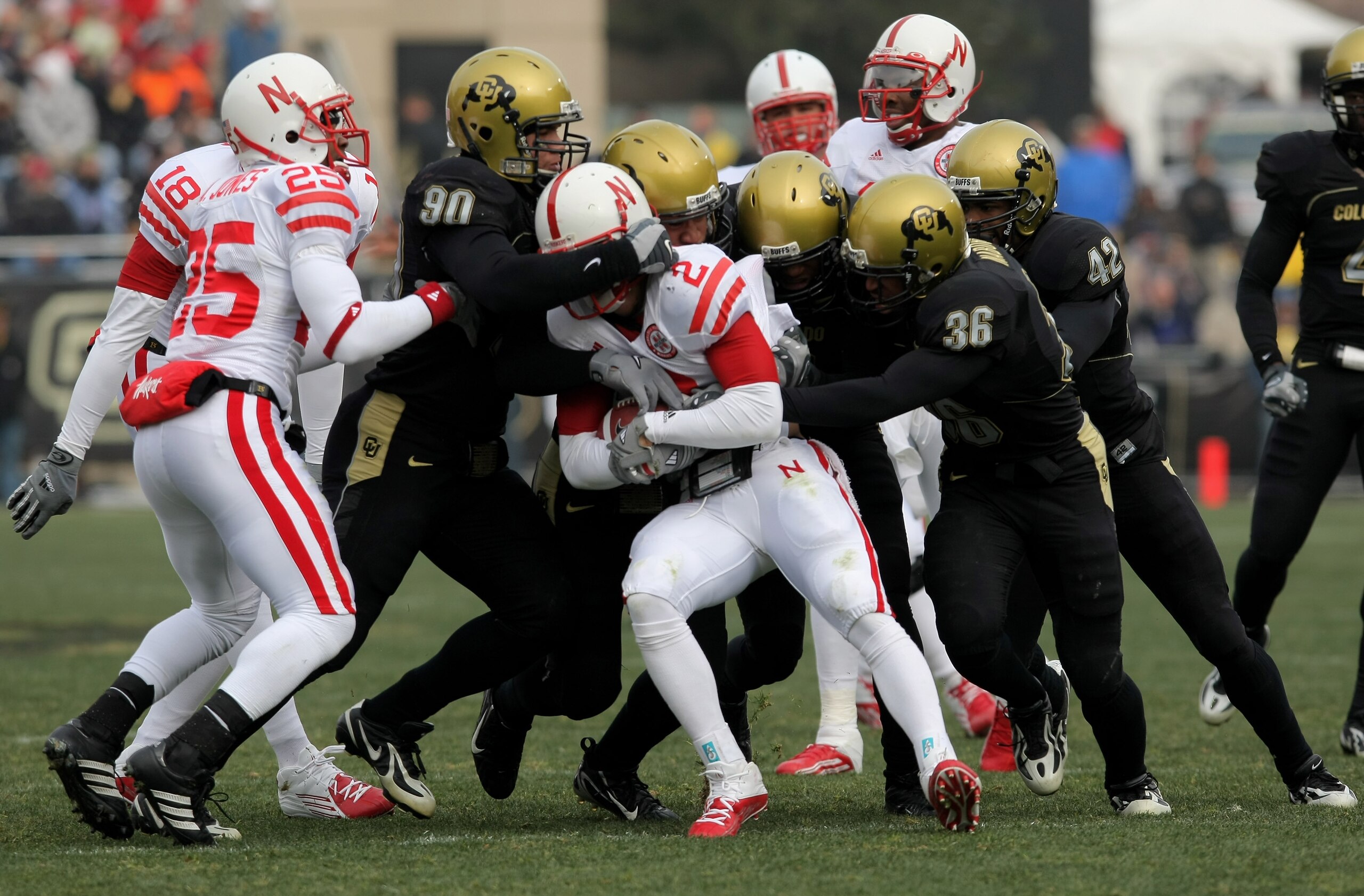 BOULDER, CO - NOVEMBER 23:  Cortney Grixby #2 of the Nebraska Cornhuskers is stopped by Marquez Herrod #90, Cory Nabors #36 and a host of teammates of the Colorado Buffaloes on a kickoff return during Big 12 College Football action at Folsom Field on Nove