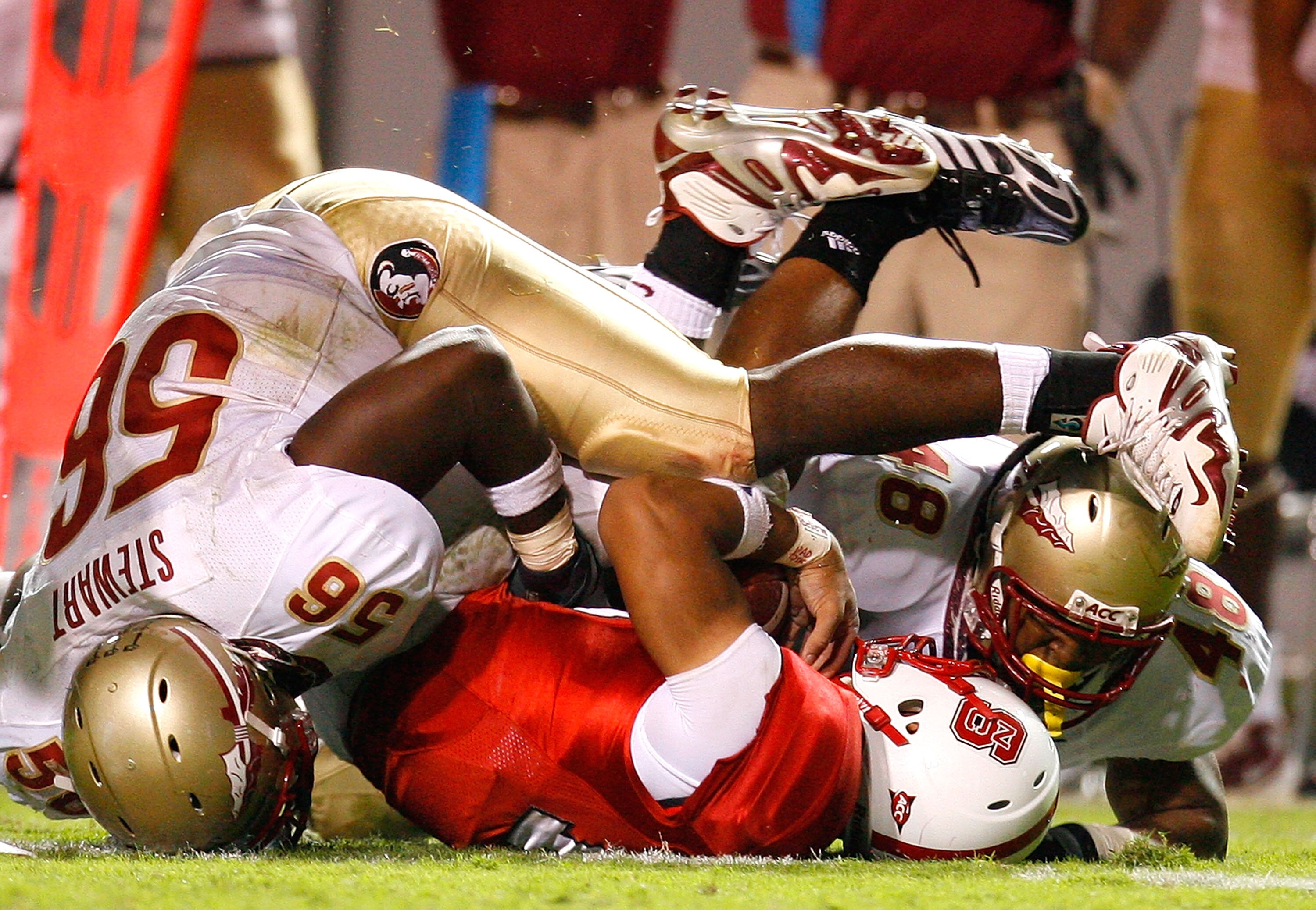 RALEIGH, NC - OCTOBER 16:  Kendrick Stewart #56 and Recardo Wright #48 of the Florida State Seminoles sack quarterback Russell Wilson #16 of the North Carolina State Wolfpack during the game at Carter-Finley Stadium on September 16, 2008 in Raleigh, North
