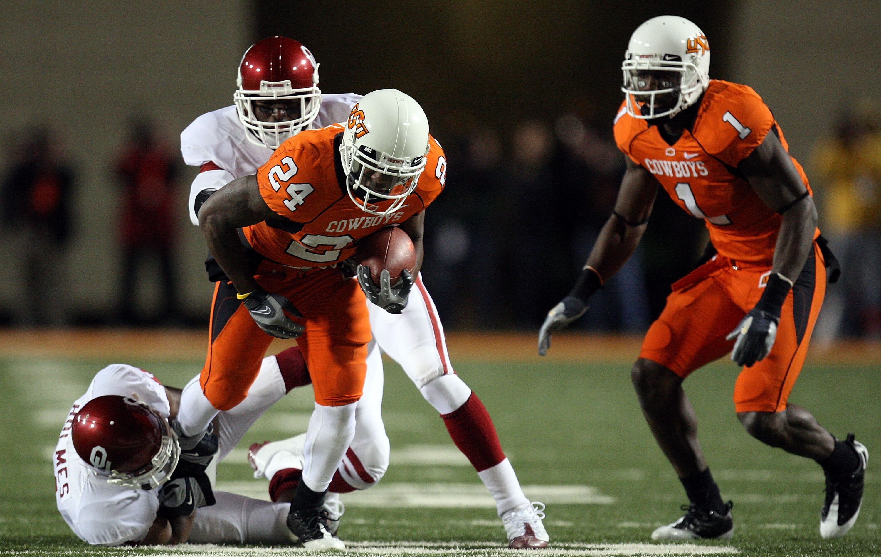 STILLWATER, OK - NOVEMBER 29:  Running back Kendall Hunter #24 of the Oklahoma State Cowboys runs the ball against Lendy Holmes #11 of the Oklahoma Sooners at Boone Pickens Stadium on November 29, 2008 in Stillwater, Oklahoma.  (Photo by Ronald Martinez/G