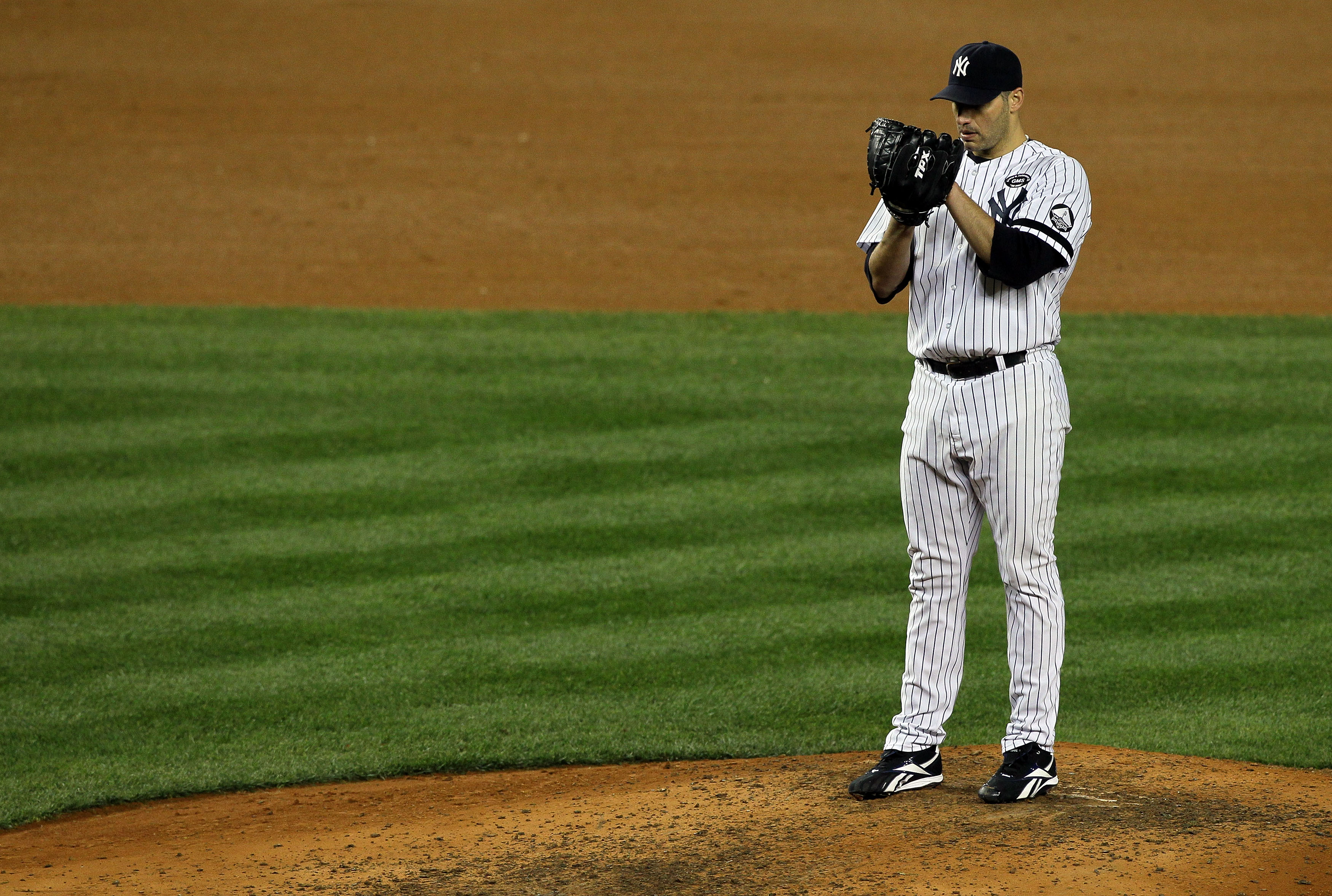 NEW YORK - OCTOBER 18:  Starting pitcher Andy Pettitte #46 of the New York Yankees gets set to throw a pitch against the Texas Rangers in Game Three of the ALCS during the 2010 MLB Playoffs at Yankee Stadium on October 18, 2010 in New York, New York.  (Ph