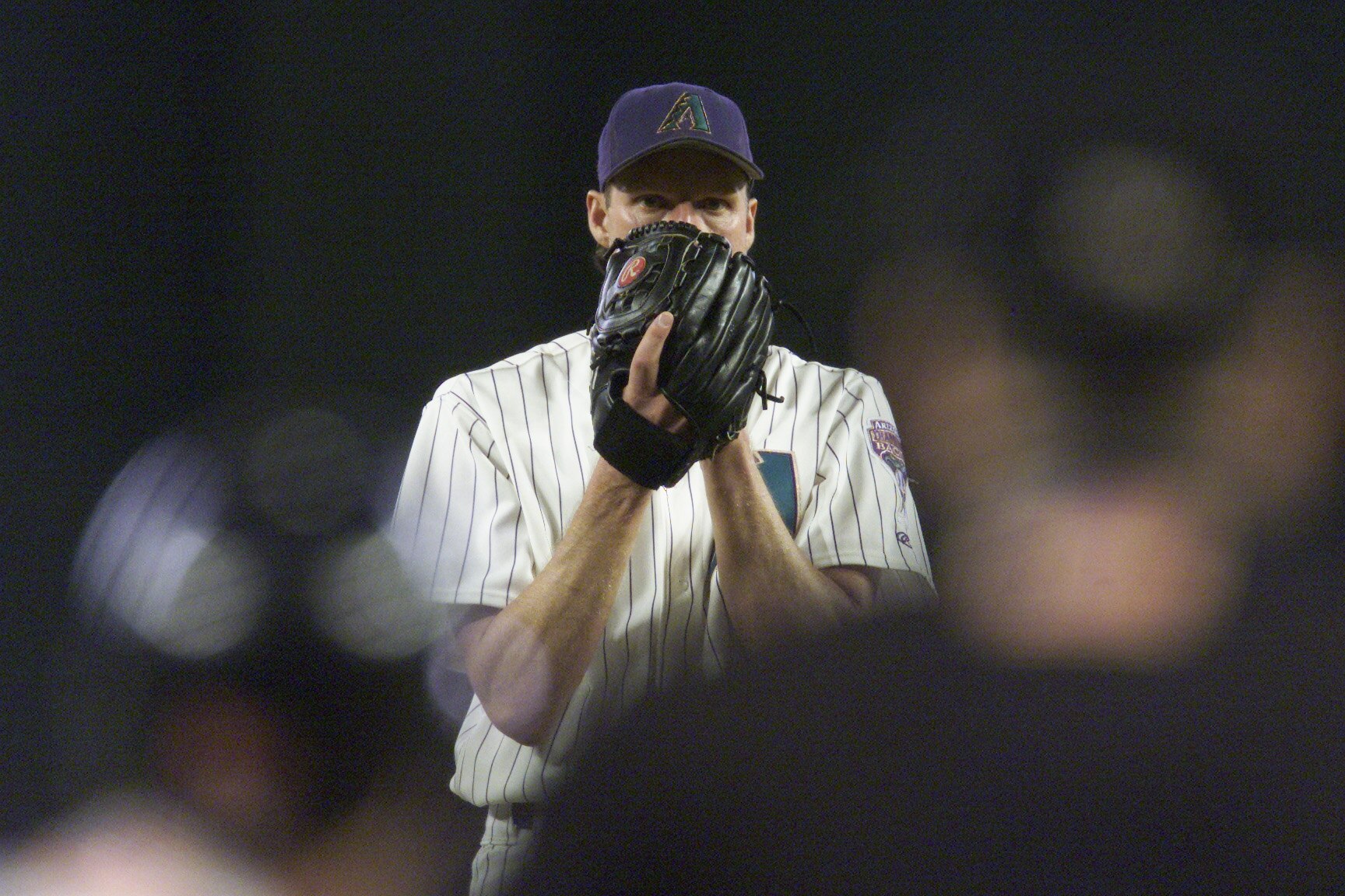 PHOENIX - OCTOBER 16:  Pitcher Randy Johnson #51 of the Arizona Diamondbacks looks in for the sign during Game 1 of the National League Championship Series against the Atlanta Braves on October 16, 2001 at Bank One Ballpark in Phoenix, Arizona.  The Diamo