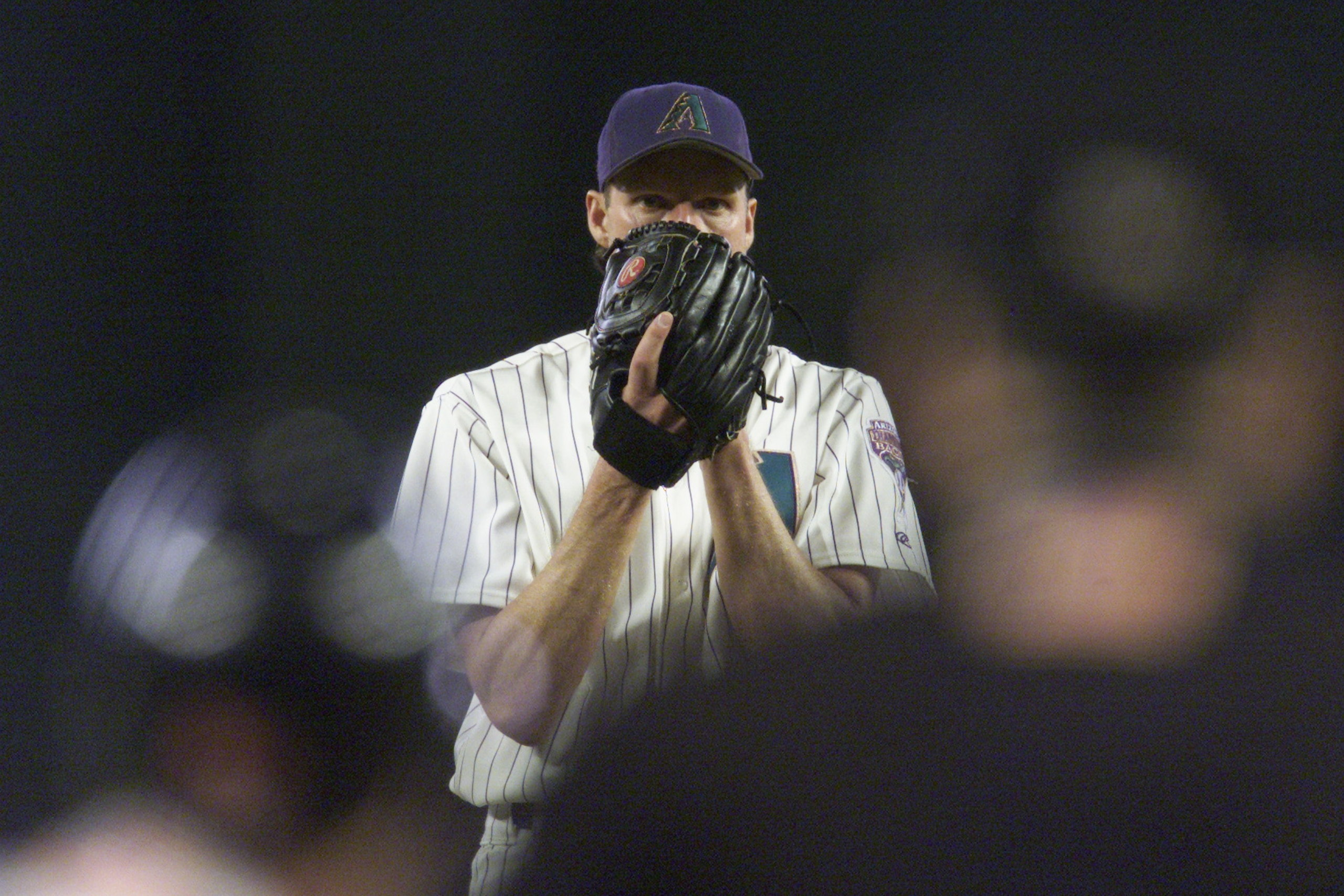PHOENIX - OCTOBER 16:  Pitcher Randy Johnson #51 of the Arizona Diamondbacks looks in for the sign during Game 1 of the National League Championship Series against the Atlanta Braves on October 16, 2001 at Bank One Ballpark in Phoenix, Arizona.  The Diamo
