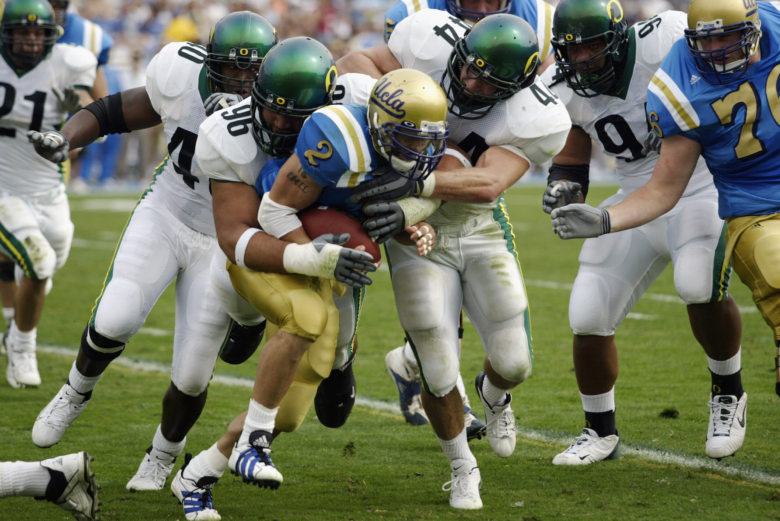 PASADENA, CA - OCTOBER 12: Tyler Ebell #2 of the UCLA Bruins gets taken down by Haloti Ngata #96 and David Moretti #44 of the Oregon Ducks during the game on October 12, 2002 at the Rose Bowl in Pasadena, California. The Ducks went on to win by a score PASADENA, CA - OCTOBER 12: Tyler Ebell #2 of the UCLA Bruins gets taken down by Haloti Ngata #96 and David Moretti #44 of the Oregon Ducks during the game on October 12, 2002 at the Rose Bowl in Pasadena, California. The Ducks went on to win by a score
